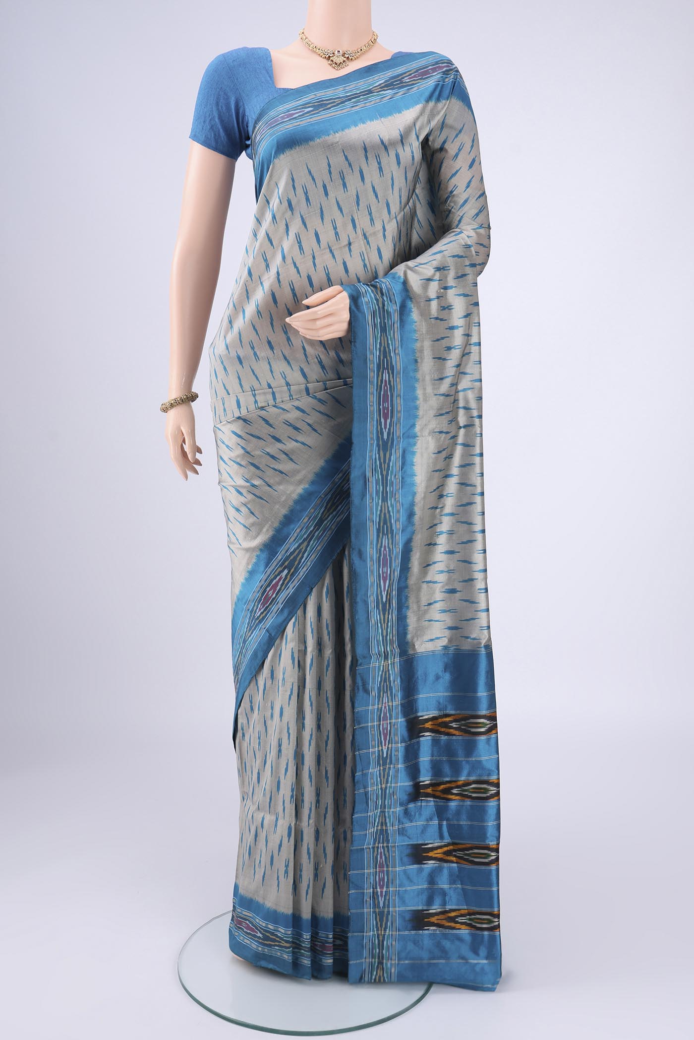Grey Pochampally Silk Saree with Ikat design on the body and Zari Border.  displayed on a mannequin