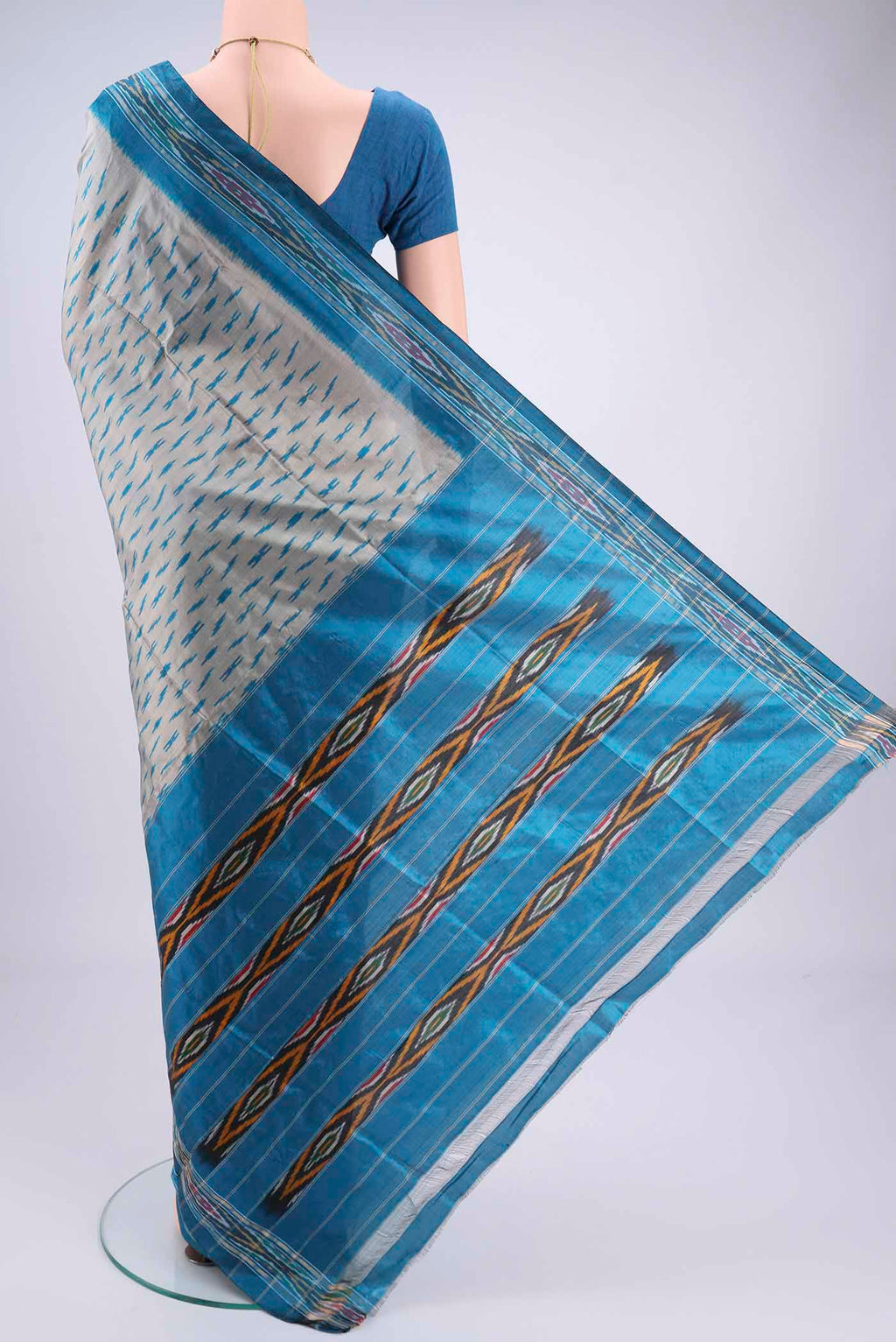 Flat view of Grey Pochampally Silk Saree with Ikat design on the body and Zari Border. 