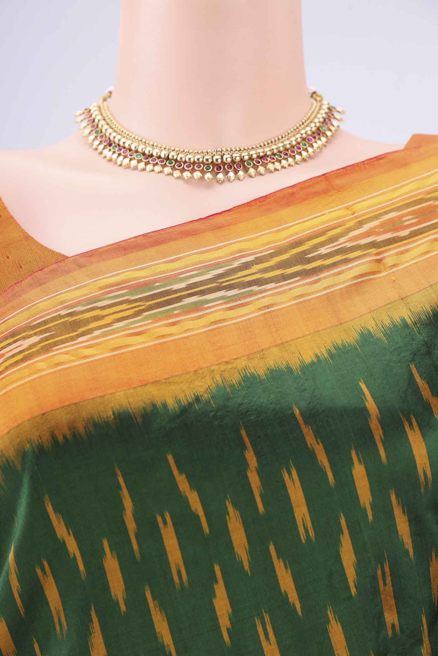 Border image of Bottle Green Pochampally Silk Saree with Checked design on the body and Ikat Border. 
