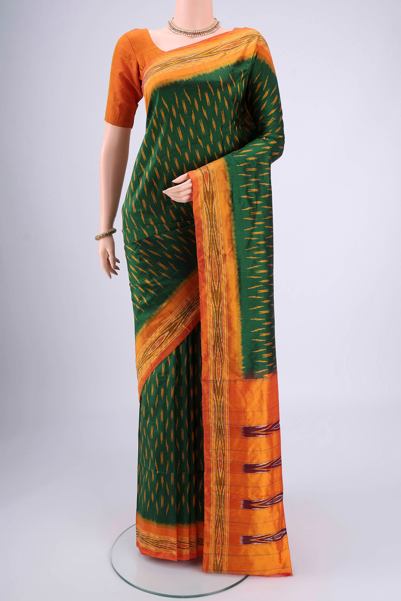Bottle Green Pochampally Silk Saree with Checked design on the body and Ikat Border.  displayed on a mannequin