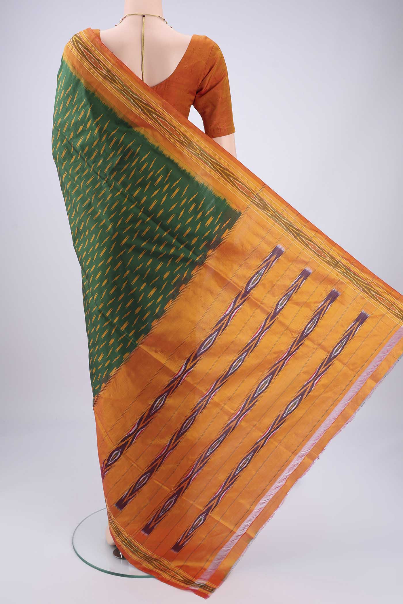 Flat view of Bottle Green Pochampally Silk Saree with Checked design on the body and Ikat Border. 
