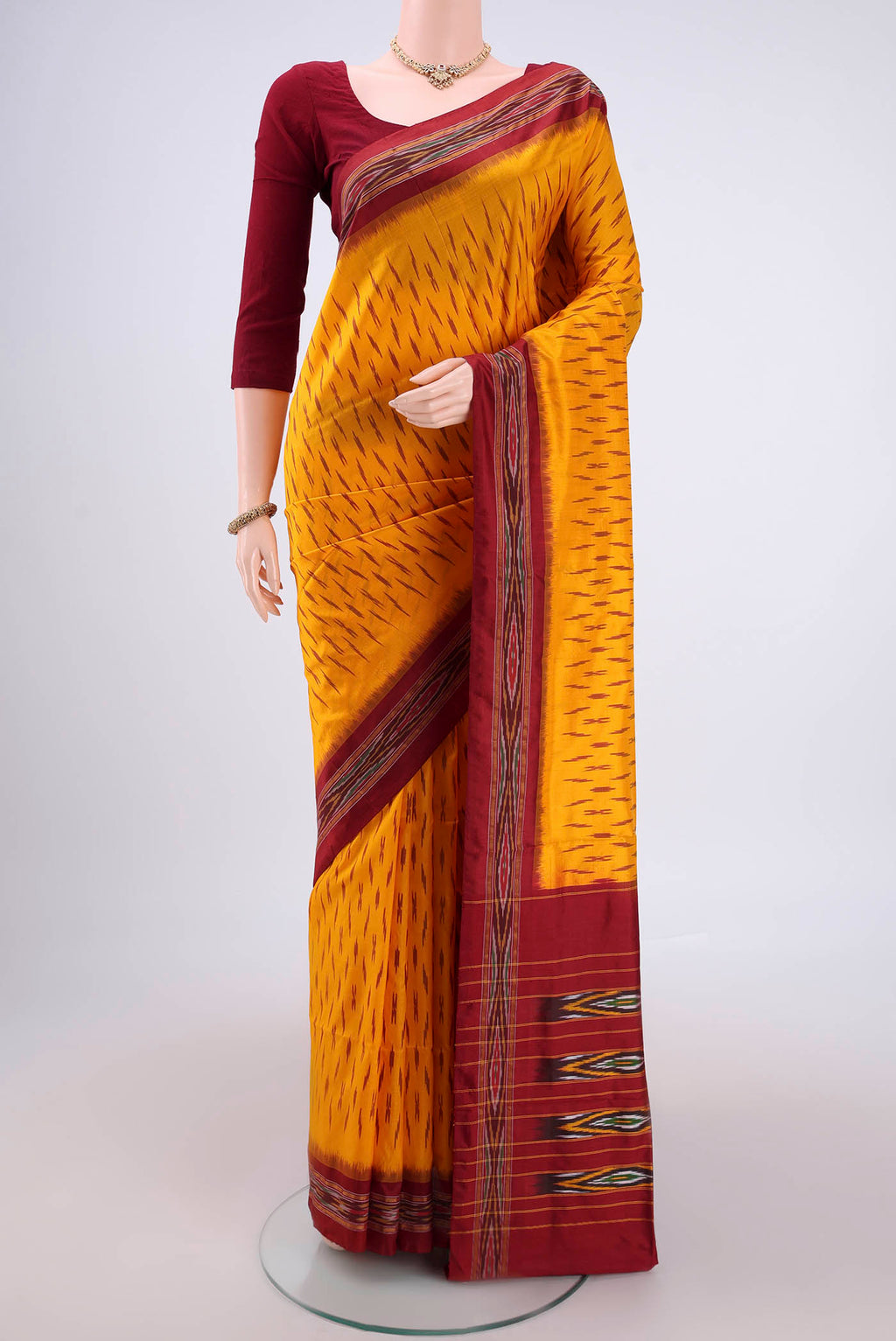 Yellow Pochampally Silk Saree with Ikat design on the body and Plain Border.  displayed on a mannequin