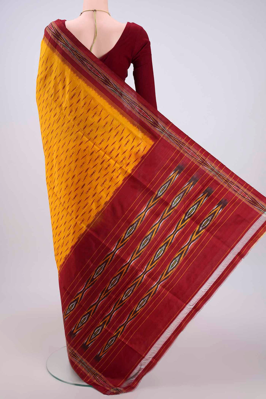 Flat view of Yellow Pochampally Silk Saree with Ikat design on the body and Plain Border. 
