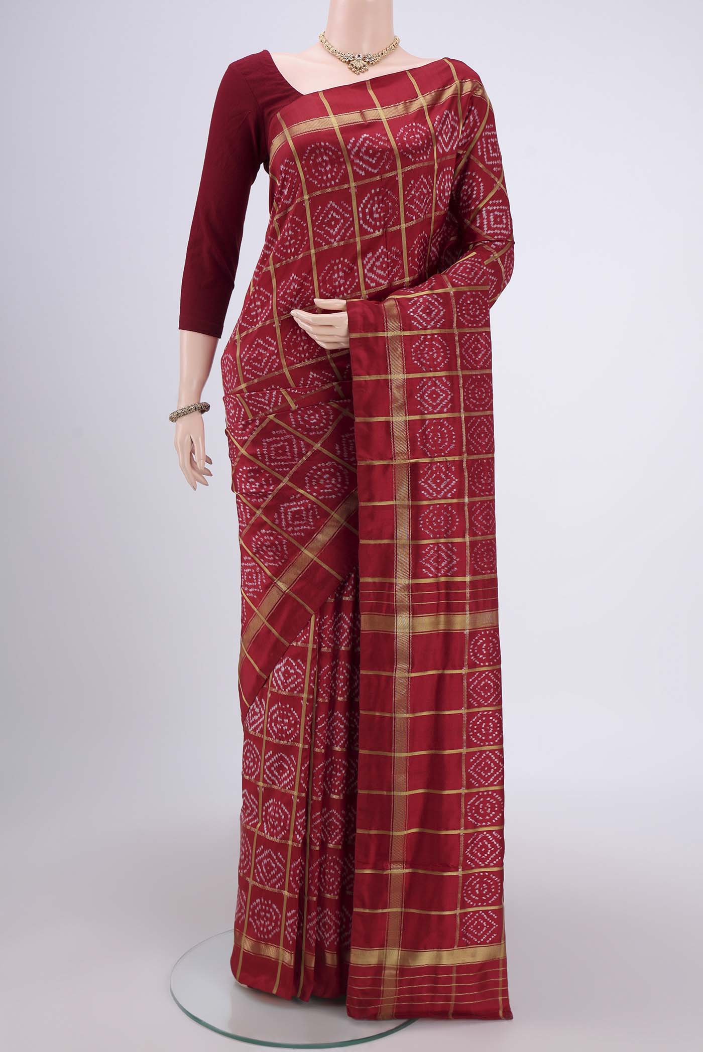 Maroon Pochampally Silk Saree with Checked design on the body and Zari Border.  displayed on a mannequin