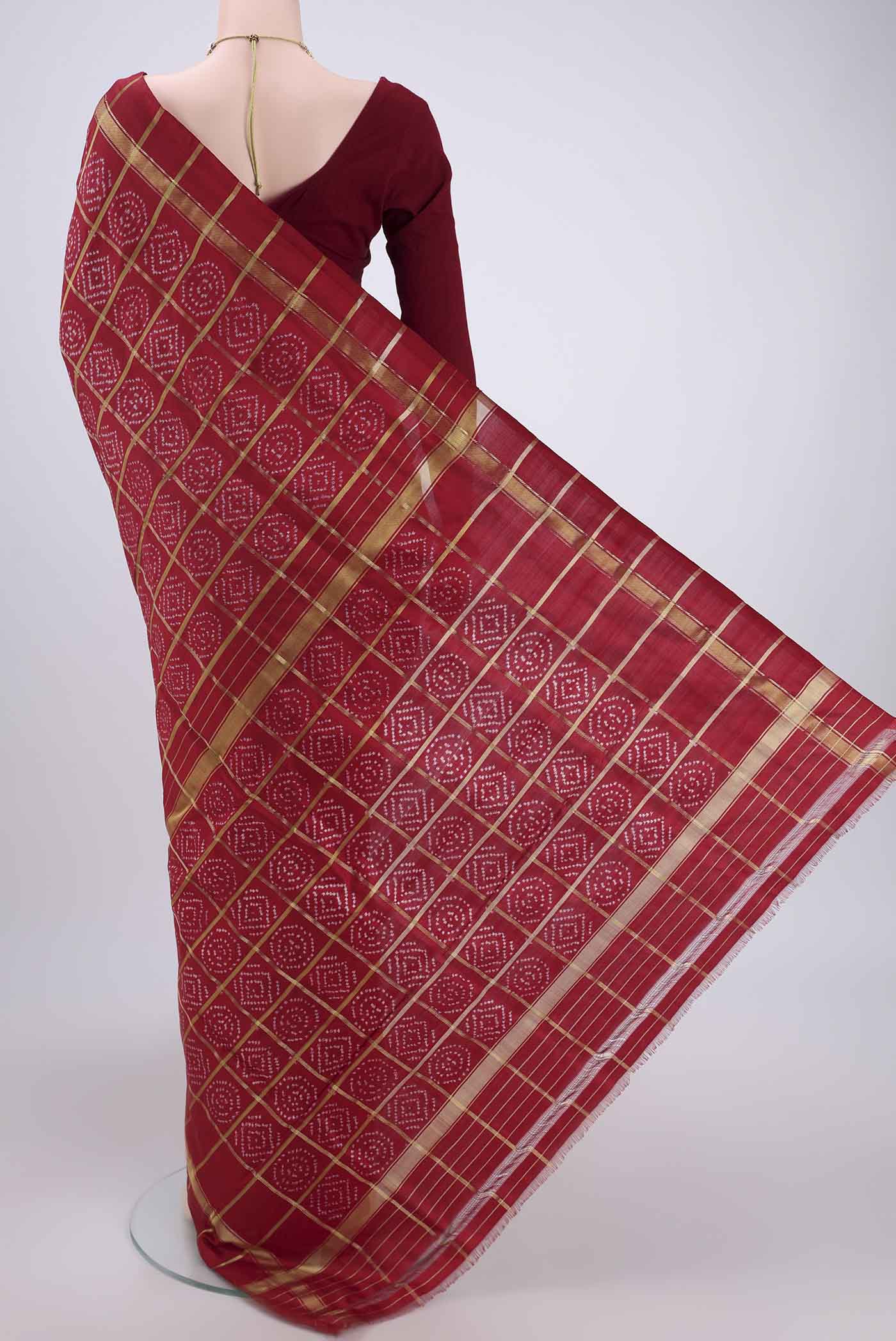 Flat view of Maroon Pochampally Silk Saree with Checked design on the body and Zari Border. 