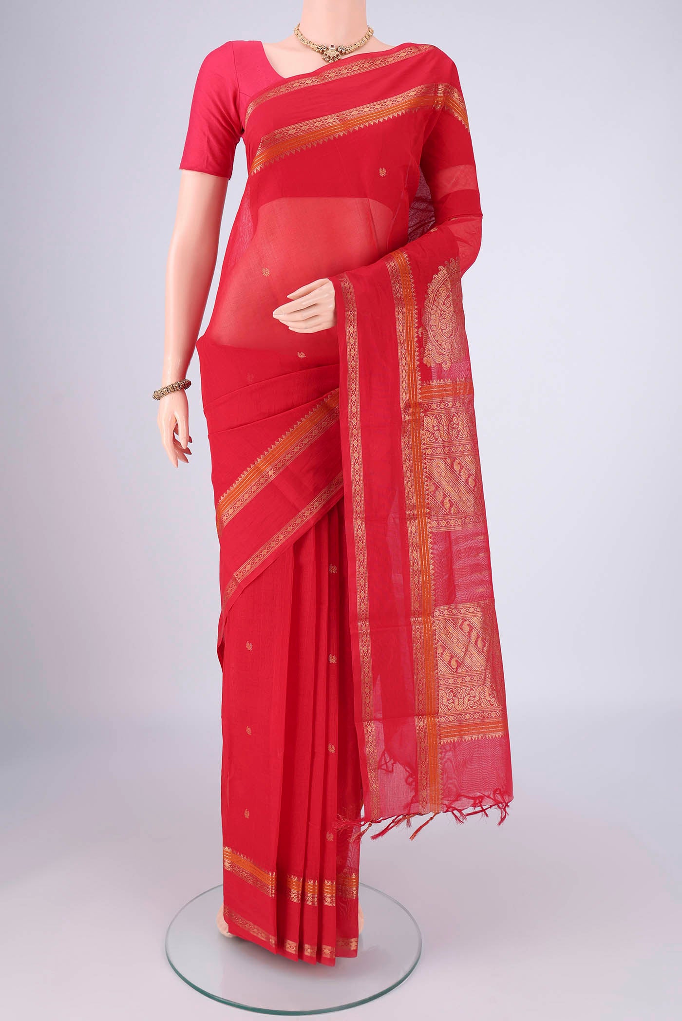 Red Kanchi Cotton Saree with Zari Butta on the body and Zari Border.  displayed on a mannequin