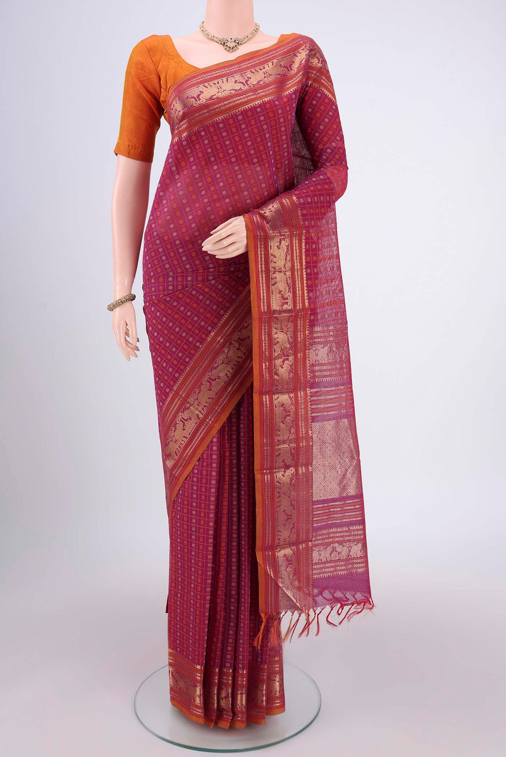 Magenta Kanchi Cotton Saree with Checked design on the body and Zari Border.  displayed on a mannequin