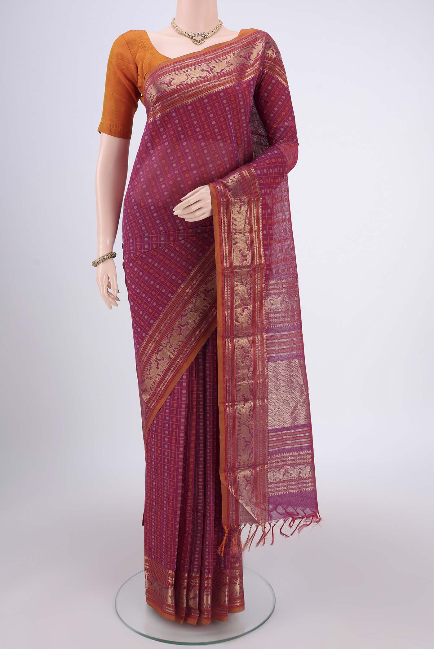 Magenta Kanchi Cotton Saree with Checked design on the body and Zari Border.  displayed on a mannequin