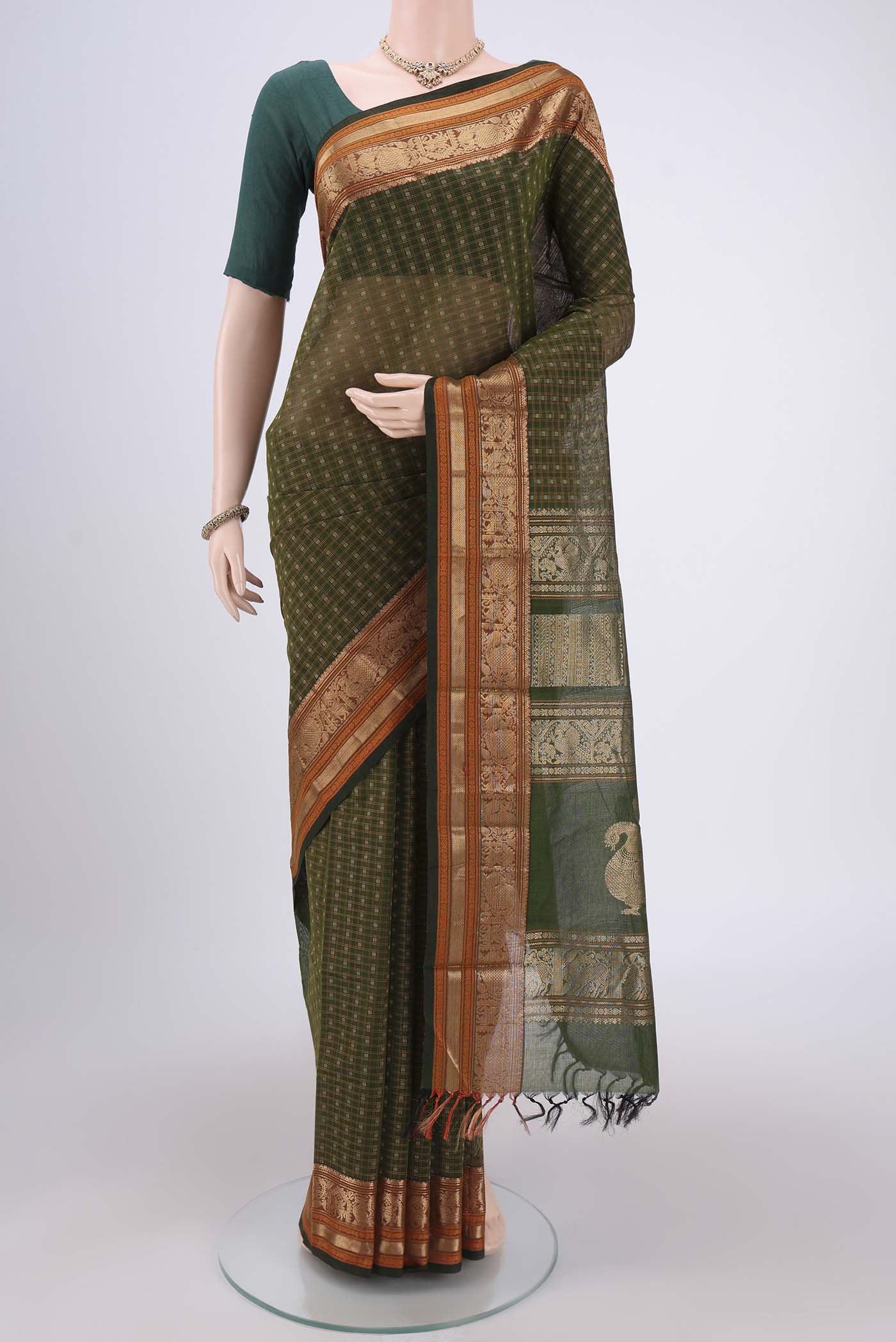 Bottle Green Kanchi Cotton Saree with Checked design on the body and Zari Border.  displayed on a mannequin
