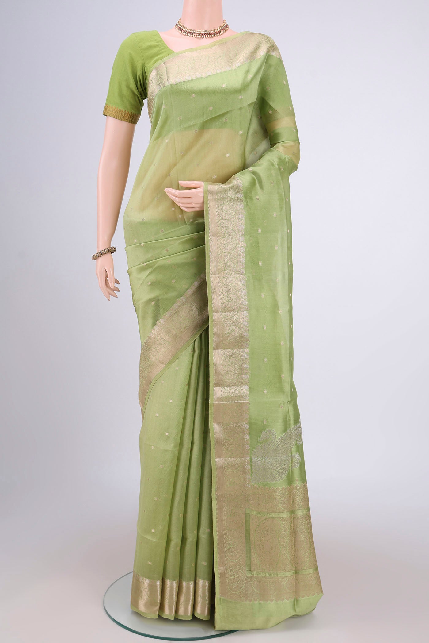 Light Green Banarasi Raw Silk Saree with Zari Butta on the body and Zari Border.  displayed on a mannequin