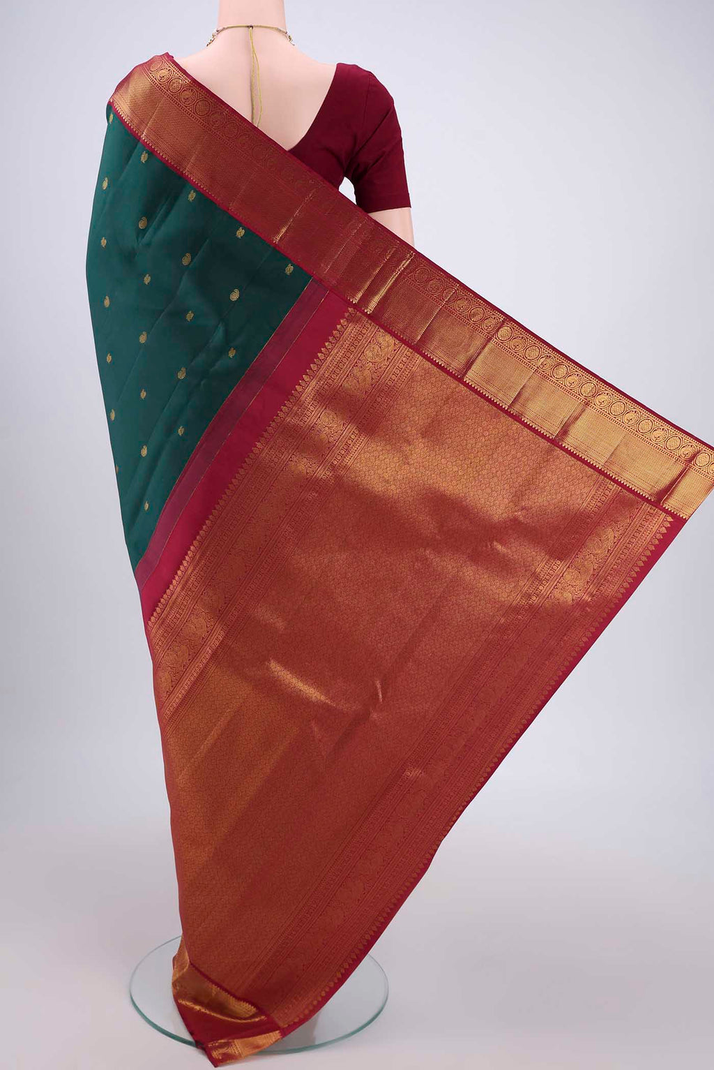 Flat view of Bottle Green Kanjivaram Silk Saree with Zari Butta on the body and Zari Border. 