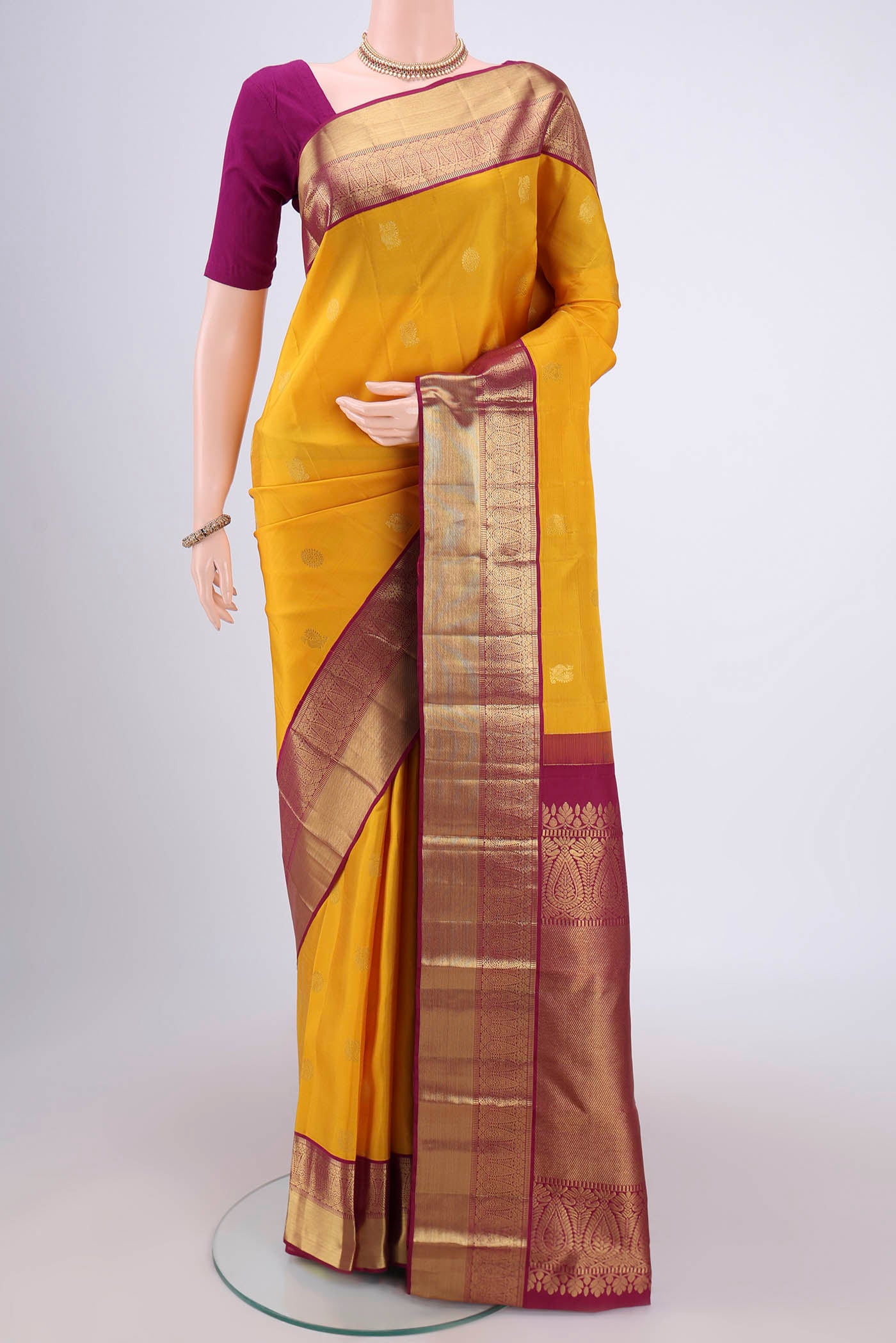 Yellow Kanjivaram Silk Saree with Zari Butta on the body and Zari Border.  displayed on a mannequin