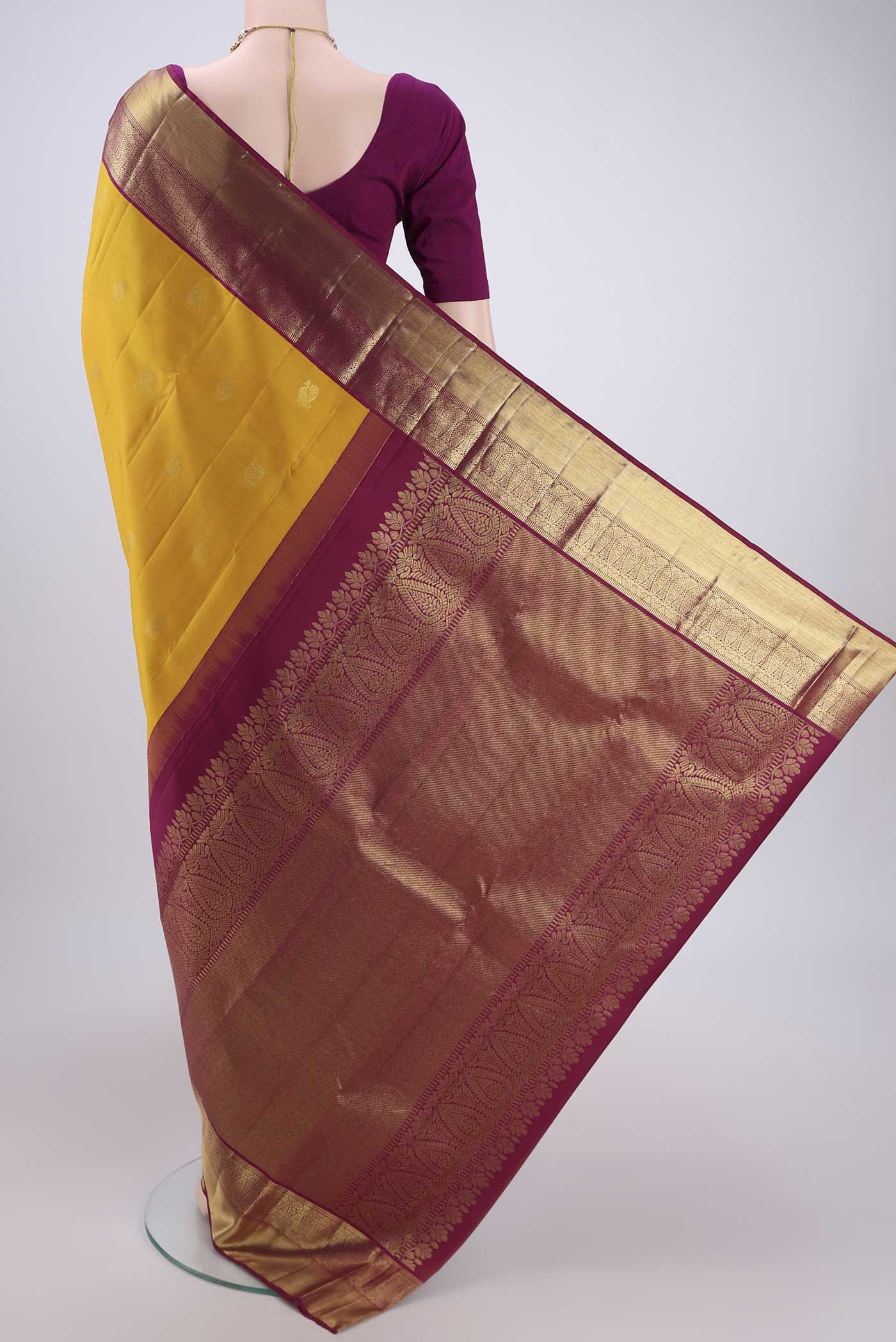 Flat view of Yellow Kanjivaram Silk Saree with Zari Butta on the body and Zari Border. 