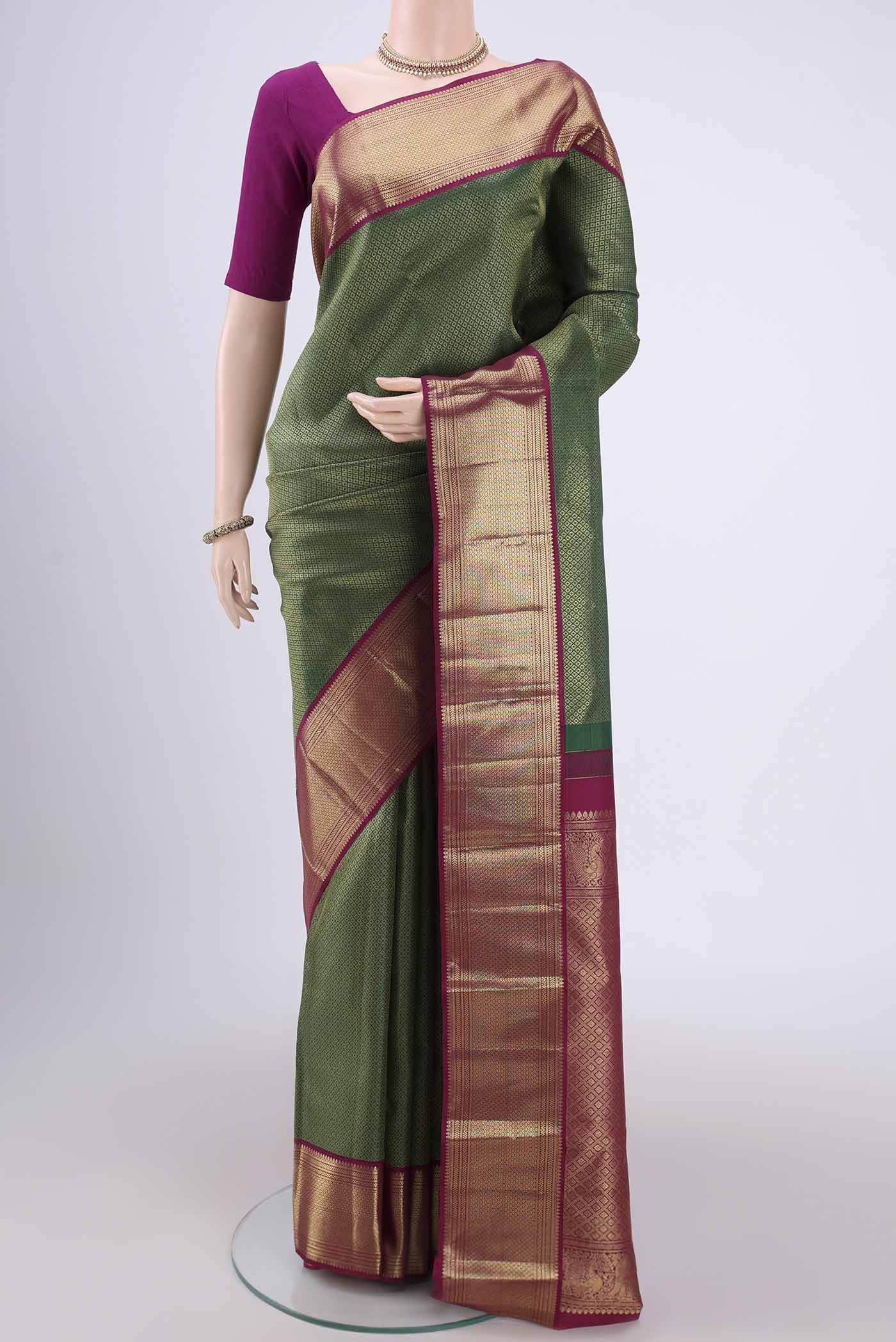 Bottle Green Kanjivaram Silk Saree with Zari Brocade on the body and Zari Border.  displayed on a mannequin