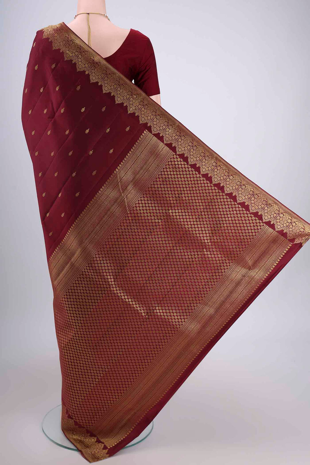 Flat view of Maroon Kanjivaram Silk Saree with Zari Butta on the body and Zari Border. 