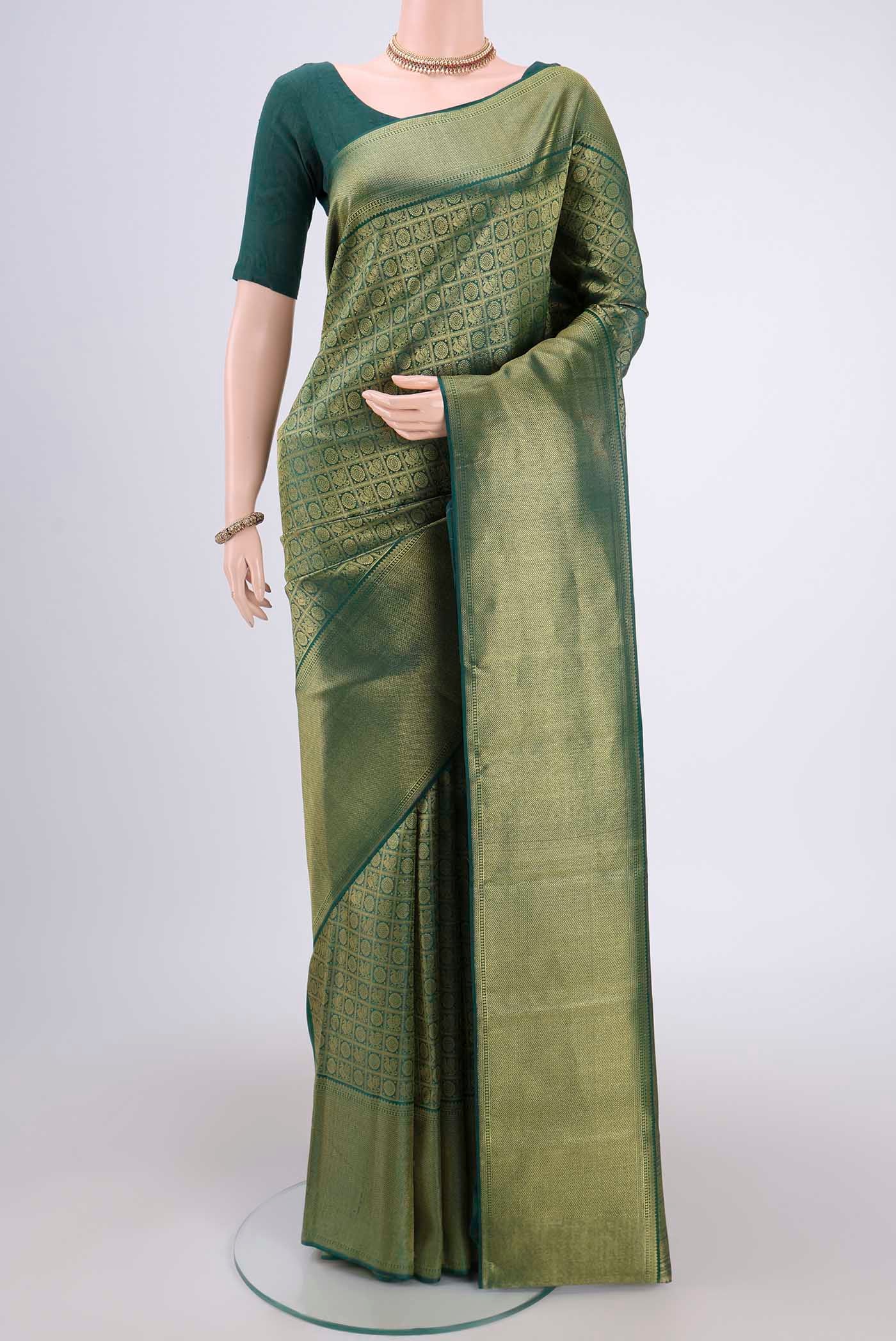 Bottle Green Kanjivaram Silk Saree with Zari Brocade on the body and Zari Border.  displayed on a mannequin