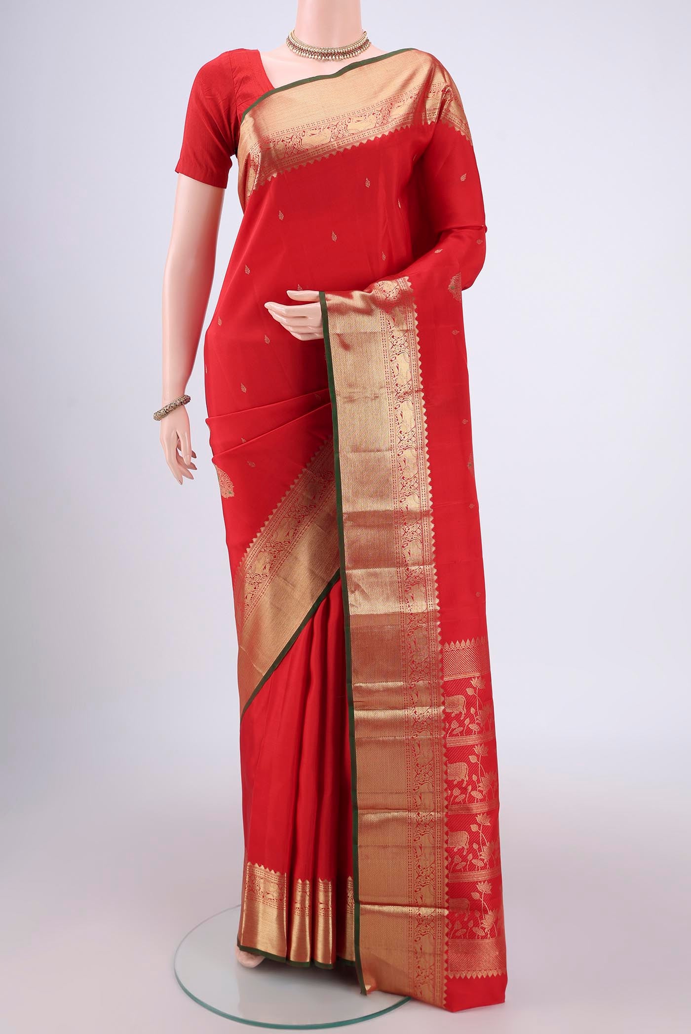 Red Kanchipuram Silk Saree with Zari And Thread Butta on the body and Zari Border.  displayed on a mannequin