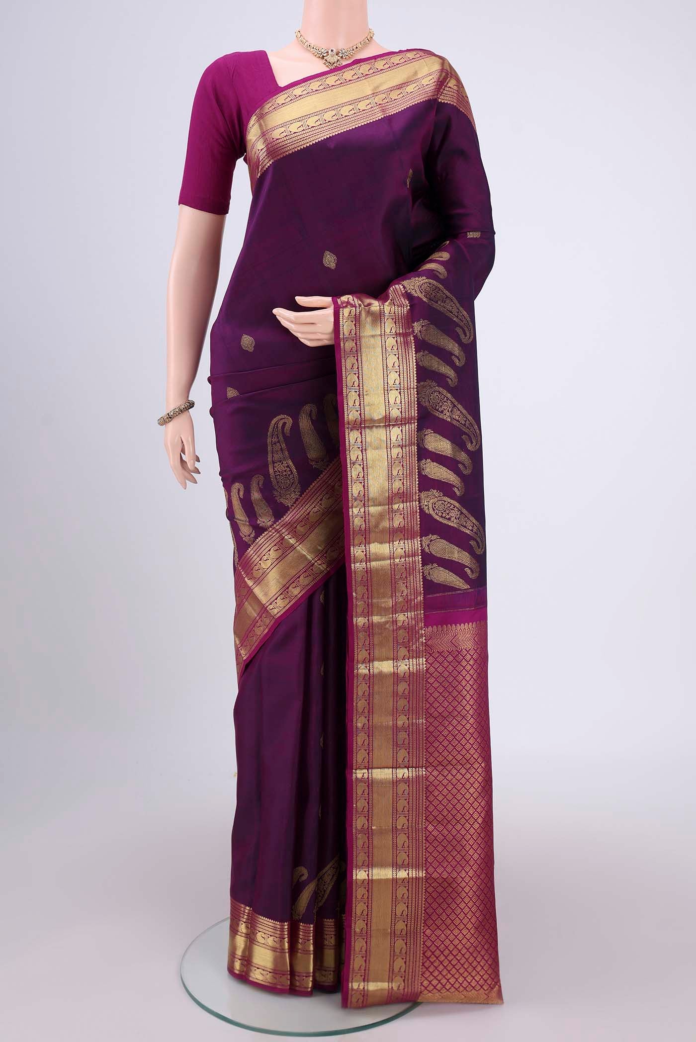 Purple Kanjivaram Silk Saree with Zari Butta on the body and Zari Border.  displayed on a mannequin
