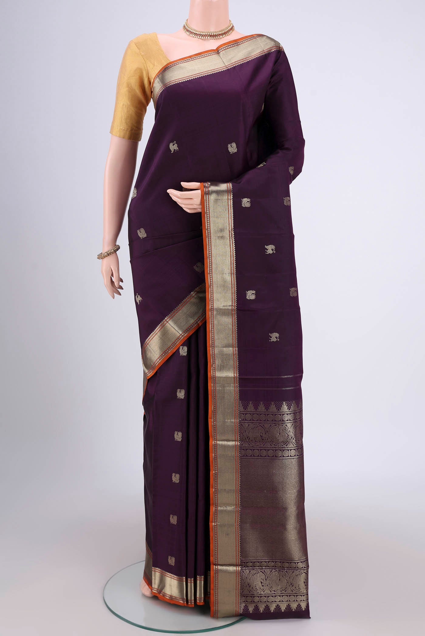 Purple Kanchipuram Silk Saree with Zari Butta on the body and Zari Border.  displayed on a mannequin