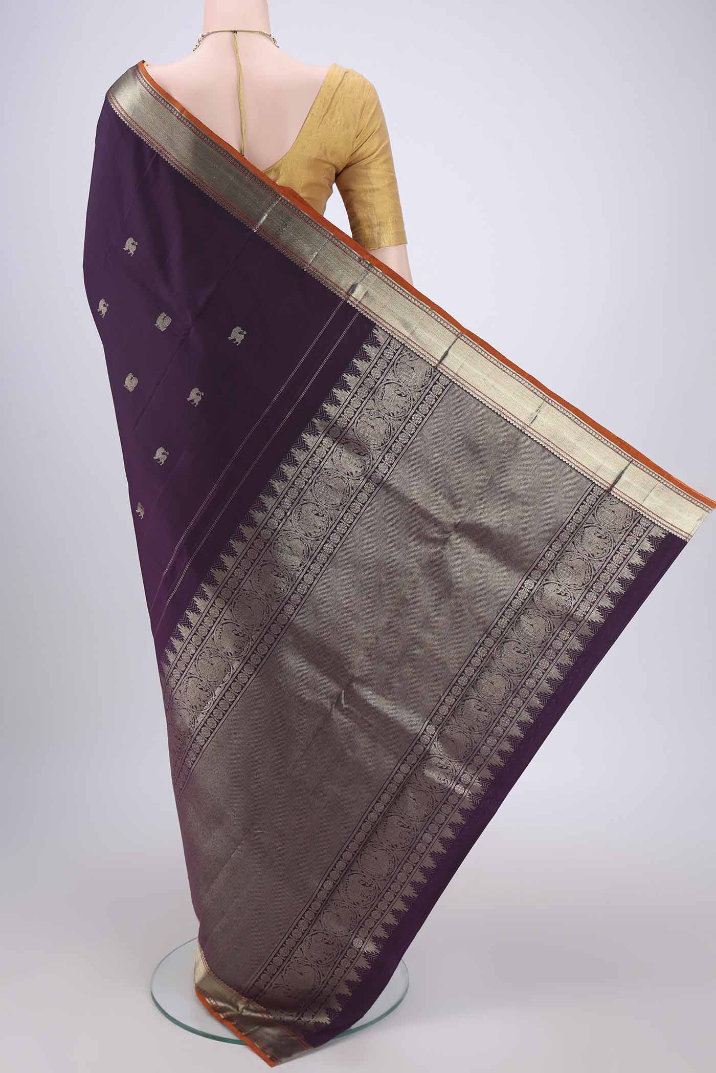 Flat view of Purple Kanchipuram Silk Saree with Zari Butta on the body and Zari Border. 