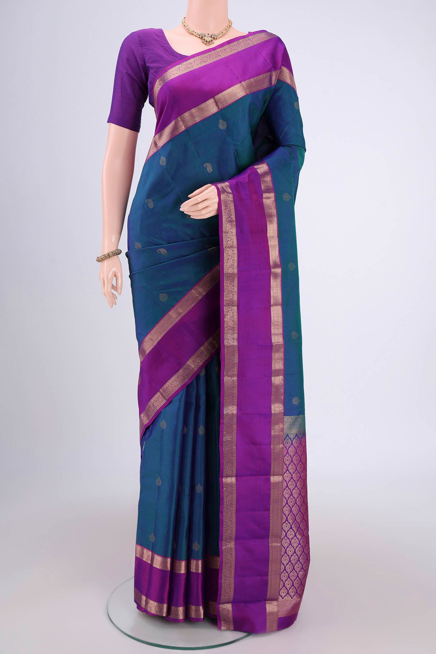 Peacock Blue Kanchipuram Silk Saree with Zari Butta on the body and Zari Border.  displayed on a mannequin