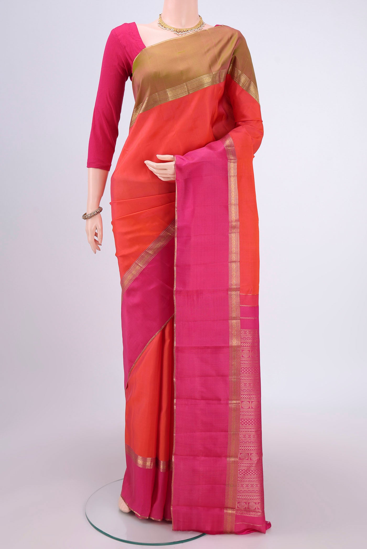Orange Kanchipuram Silk Saree with Zari Butta on the body and Ganga Jamuna Border.  displayed on a mannequin