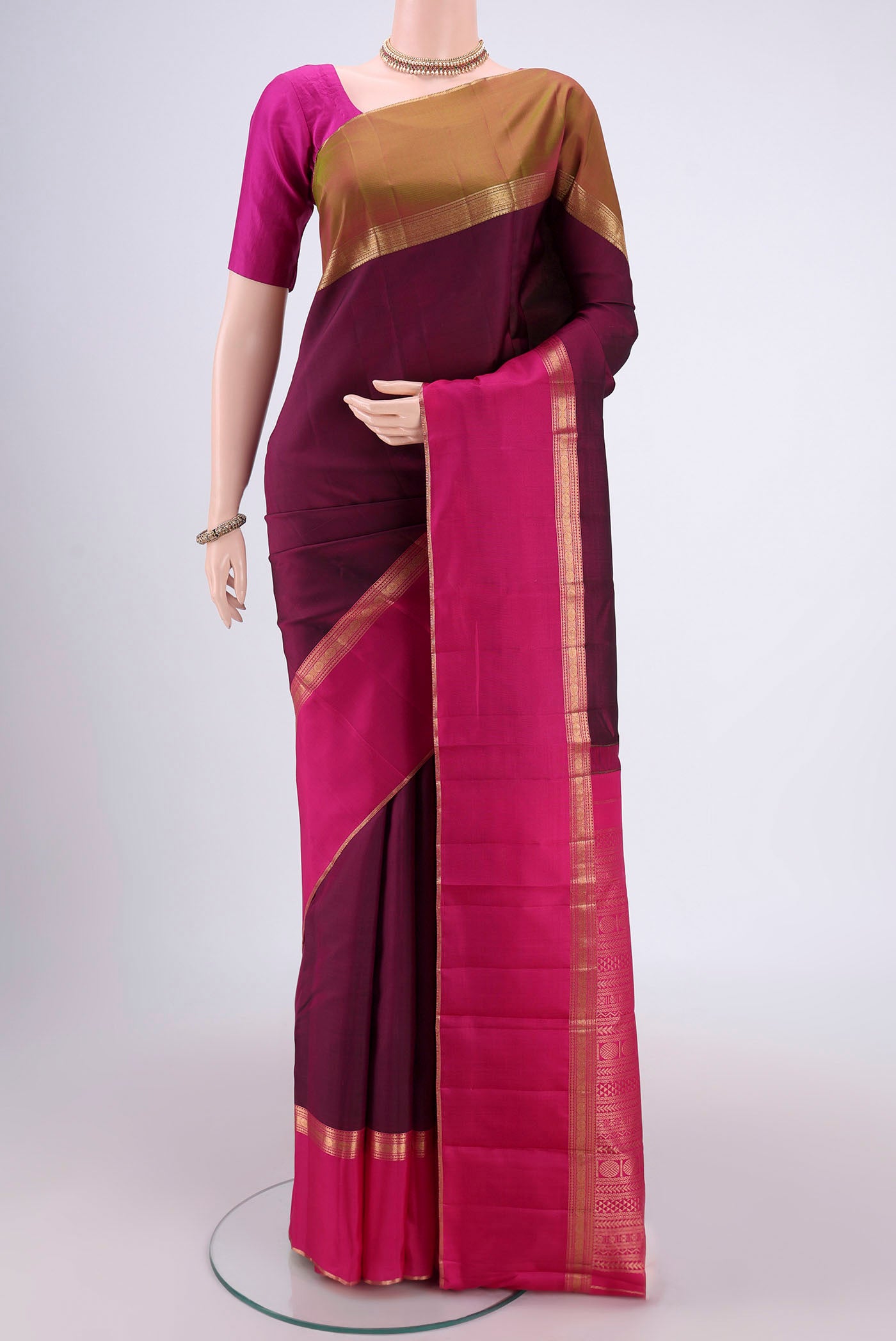 Maroon Kanchipuram Silk Saree with Zari Butta on the body and Ganga Jamuna Border.  displayed on a mannequin
