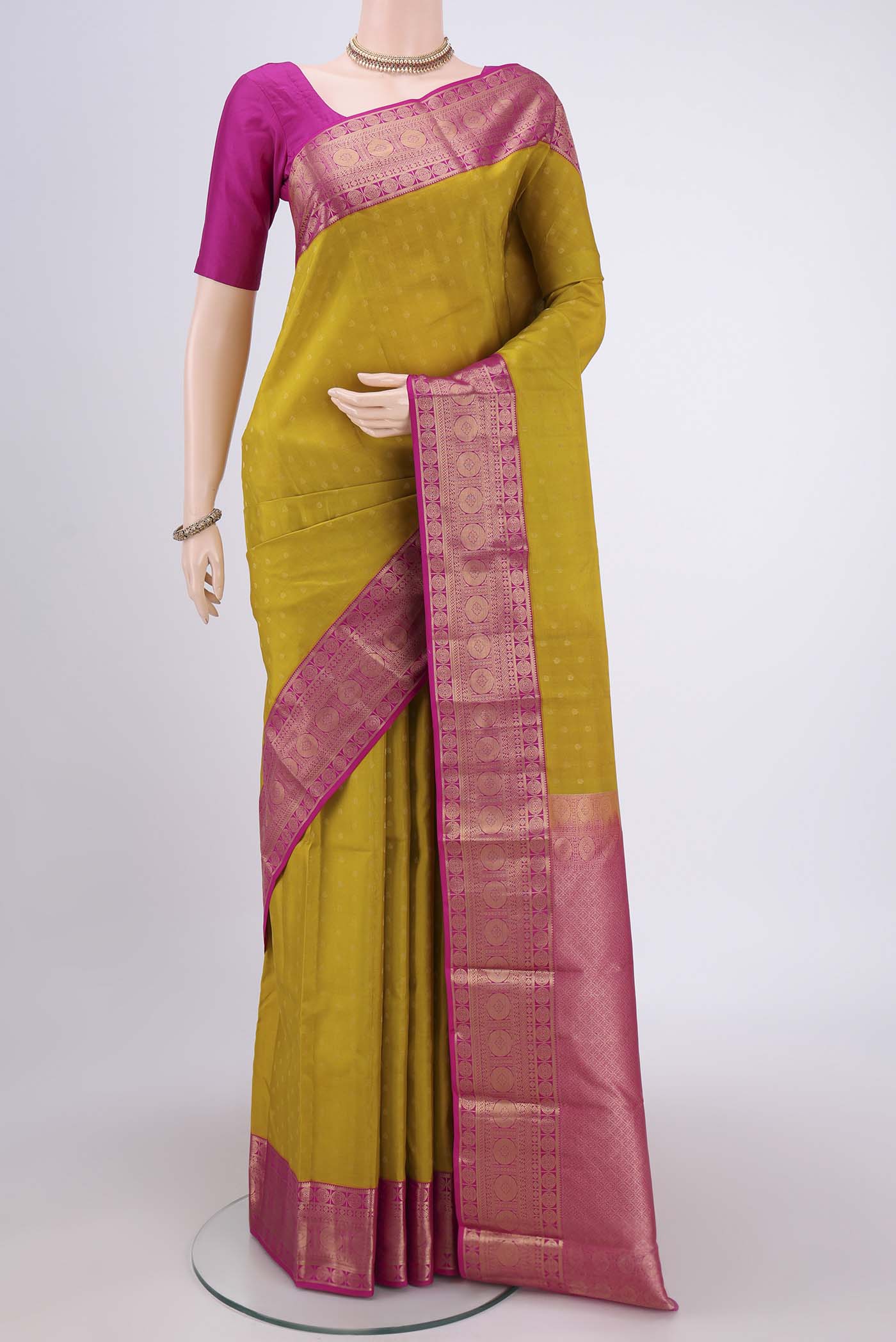 Acid Green Kanchipuram Silk Saree with Zari Butta on the body and Zari Border.  displayed on a mannequin