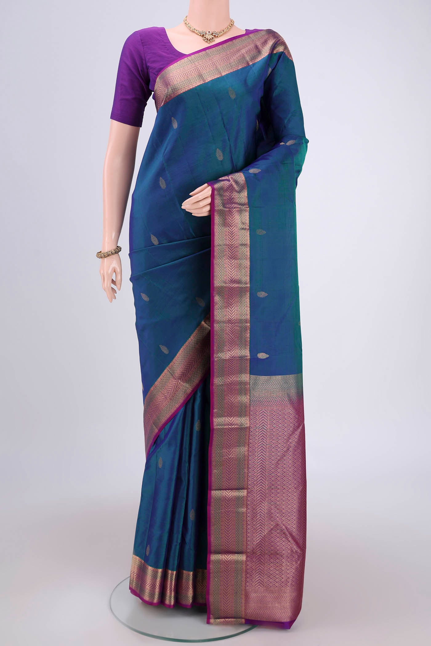 Peacock Blue Kanchipuram Silk Saree with Zari Butta on the body and Zari Border.  displayed on a mannequin