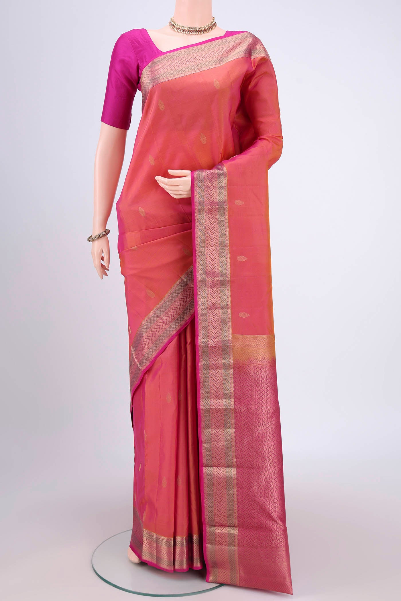 Orange Kanchipuram Silk Saree with Zari Butta on the body and Zari Border.  displayed on a mannequin
