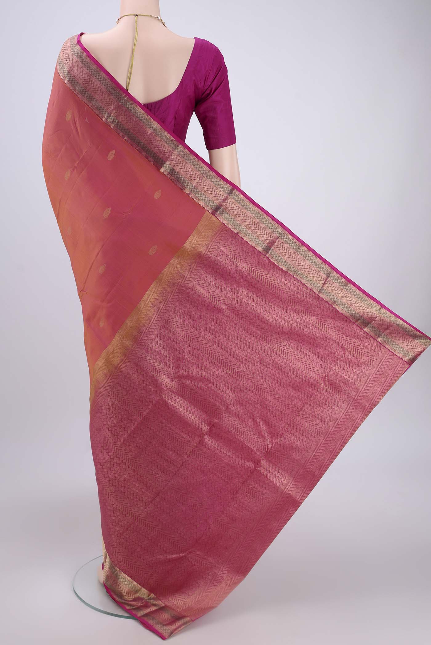 Flat view of Orange Kanchipuram Silk Saree with Zari Butta on the body and Zari Border. 