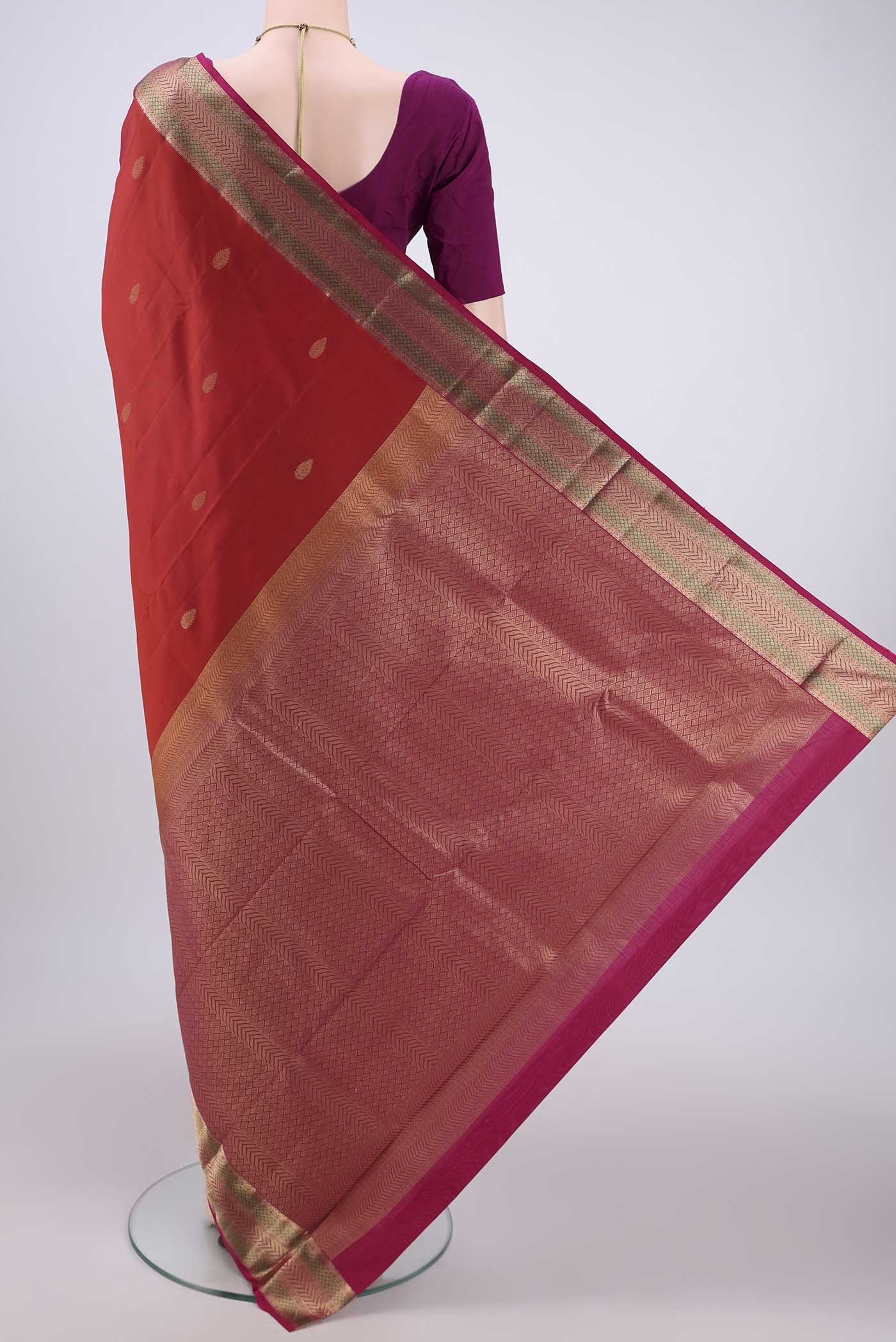 Flat view of Rust Kanchipuram Silk Saree with Zari Butta on the body and Zari Border. 