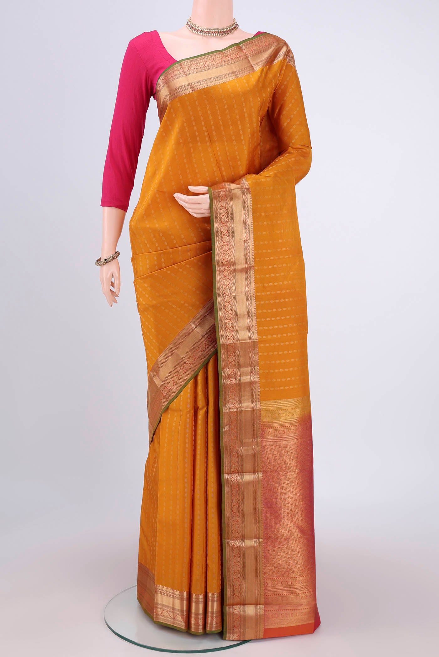Yellow Kanchipuram Silk Saree with Zari Butta on the body and Zari Border.  displayed on a mannequin