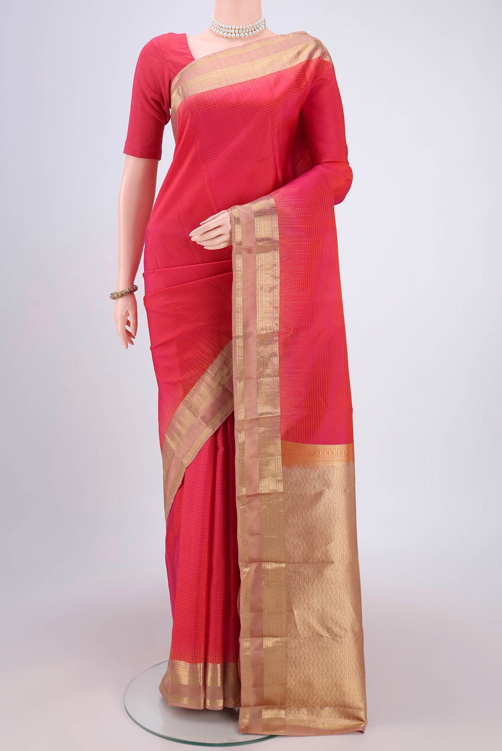 Peach Kanchipuram Silk Saree with Zari Butta on the body and Zari Border.  displayed on a mannequin