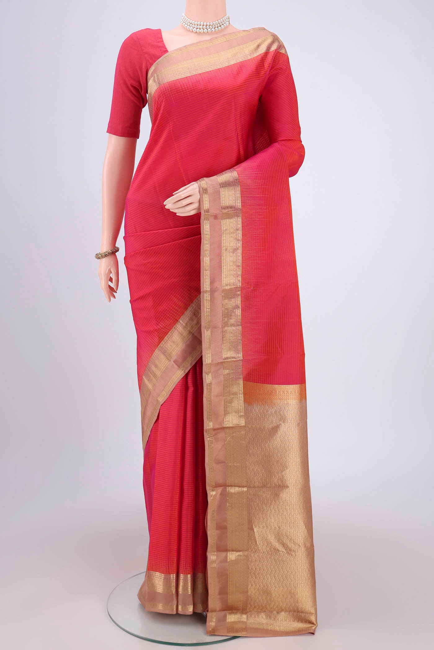 Peach Kanchipuram Silk Saree with Zari Butta on the body and Zari Border.  displayed on a mannequin