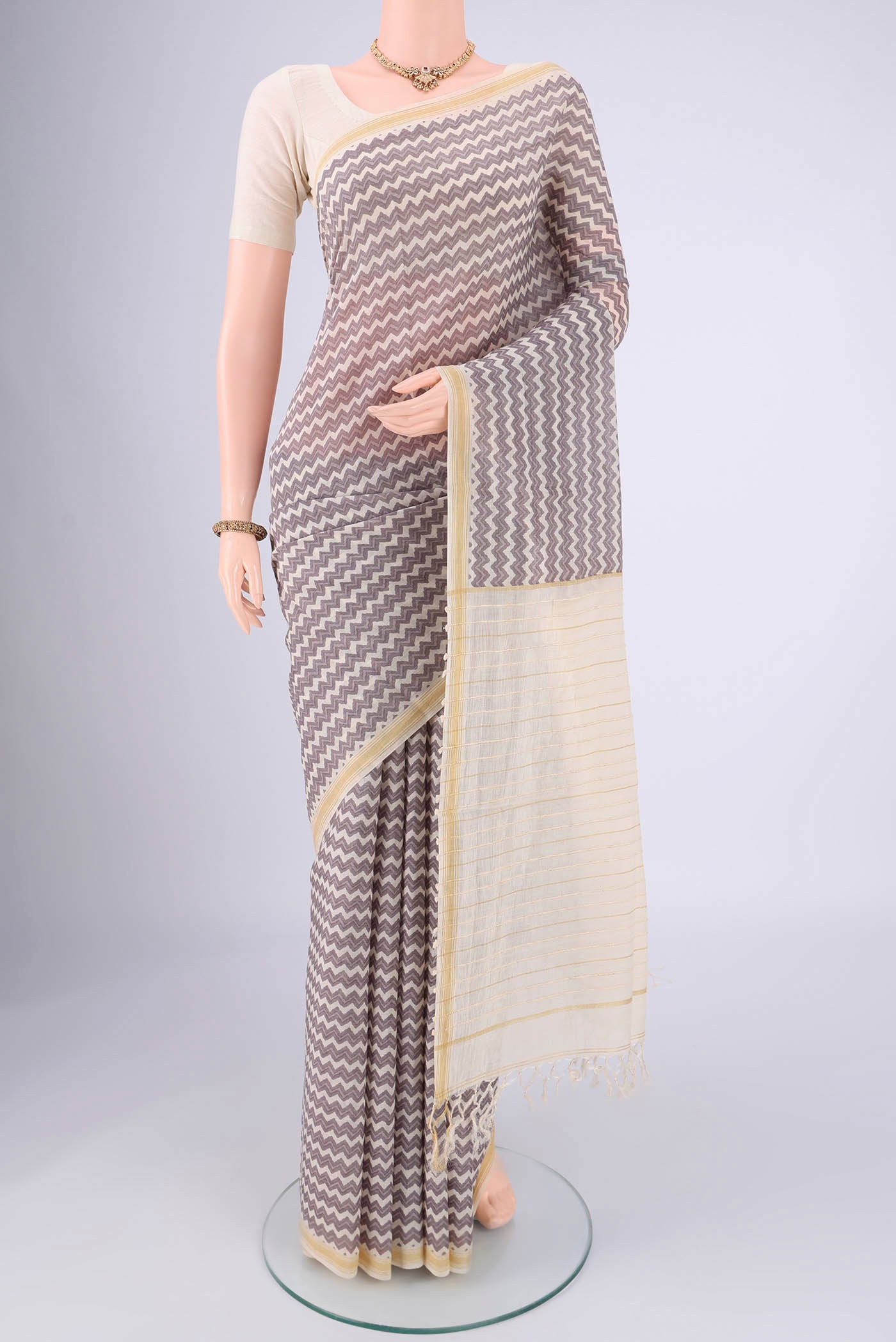 Off White Tussar Silk Saree with Floral Print on the body and Thread Border.  displayed on a mannequin