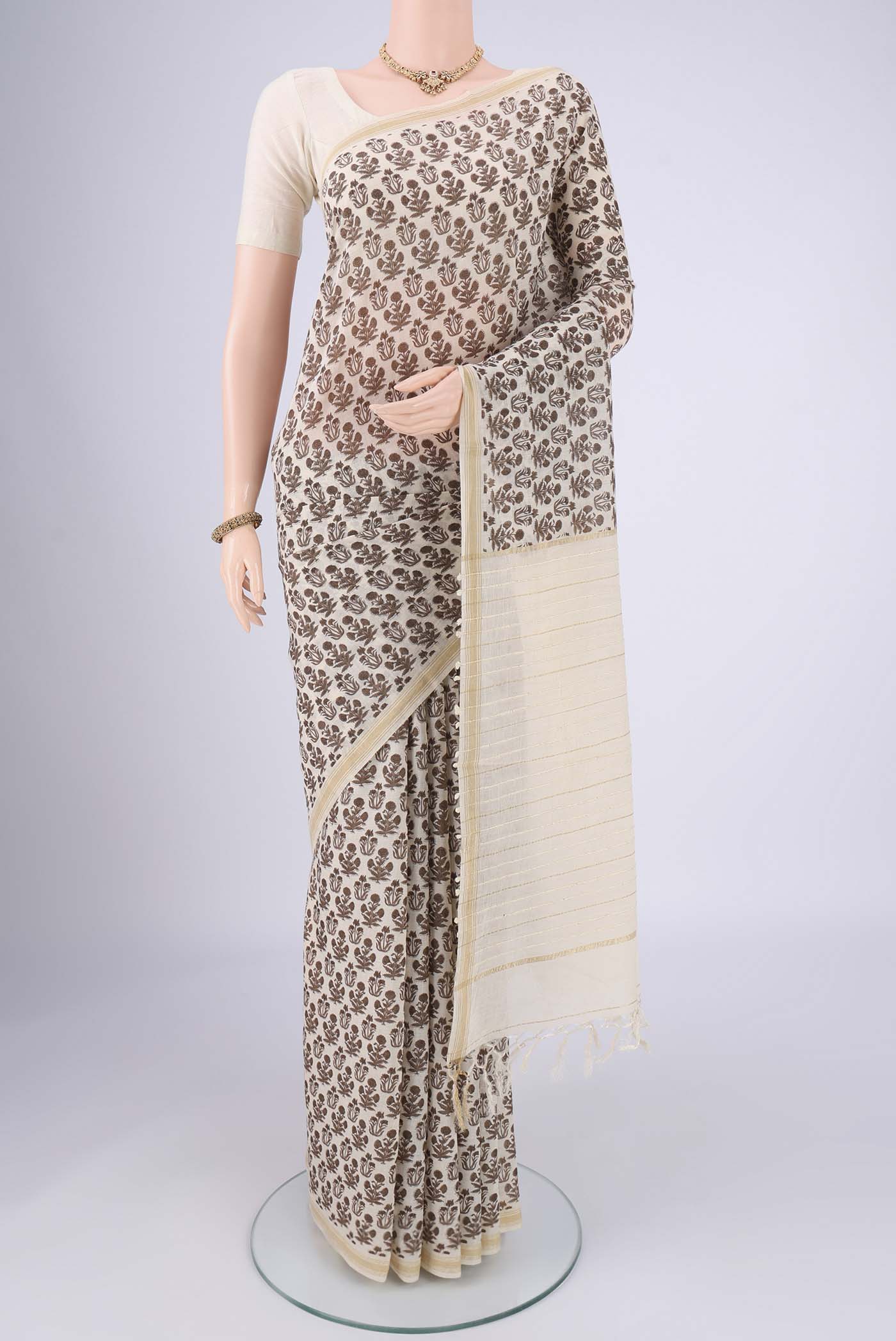 Off White Tussar Silk Saree with Floral Print on the body and Thread Border.  displayed on a mannequin