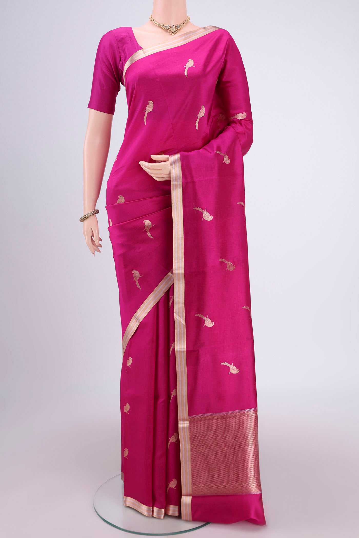 Rani Pink Banarasi Katan Silk Saree with Zari And Thread Butta on the body and Zari Border.  displayed on a mannequin