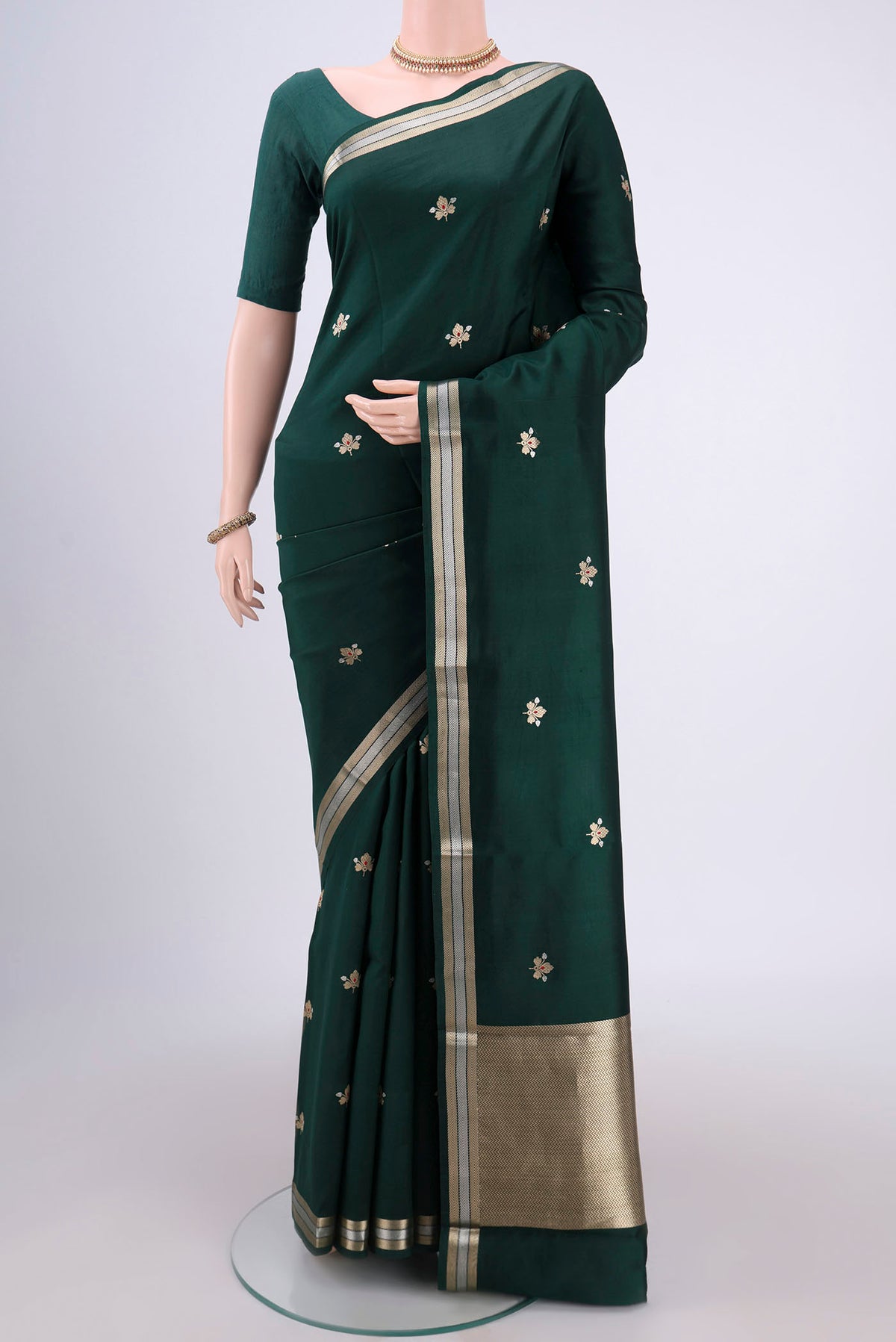Bottle Green Banarasi Katan Silk Saree with Zari Butta on the body and Zari Border.  displayed on a mannequin
