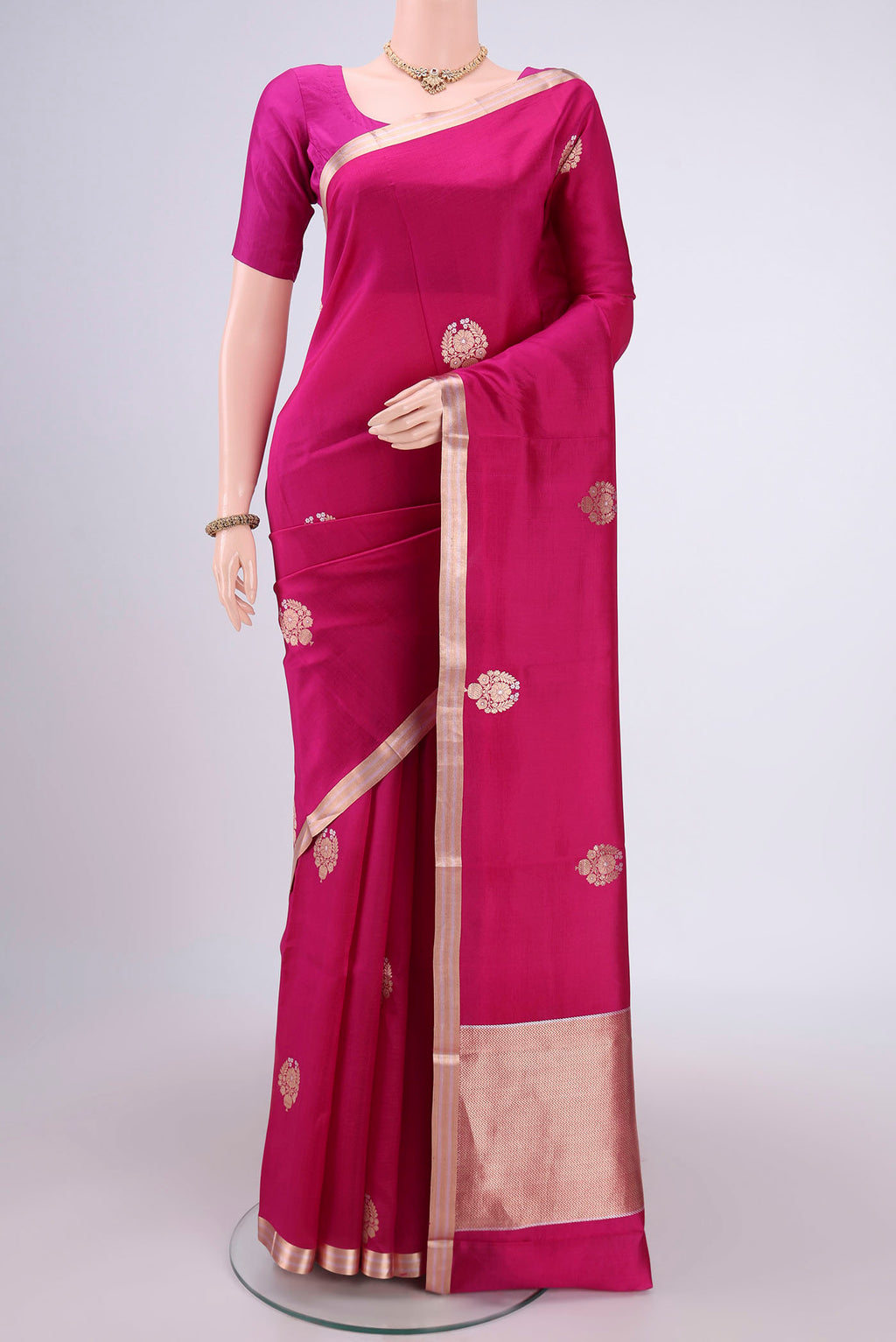 Rani Pink Banarasi Katan Silk Saree with Zari Butta on the body and Zari Border.  displayed on a mannequin