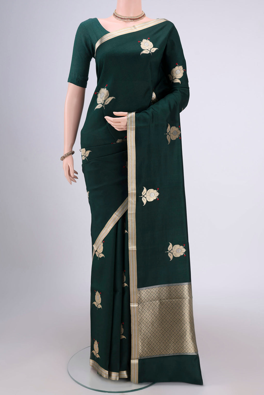 Bottle Green Banarasi Katan Silk Saree with Zari Butta on the body and Zari Border.  displayed on a mannequin