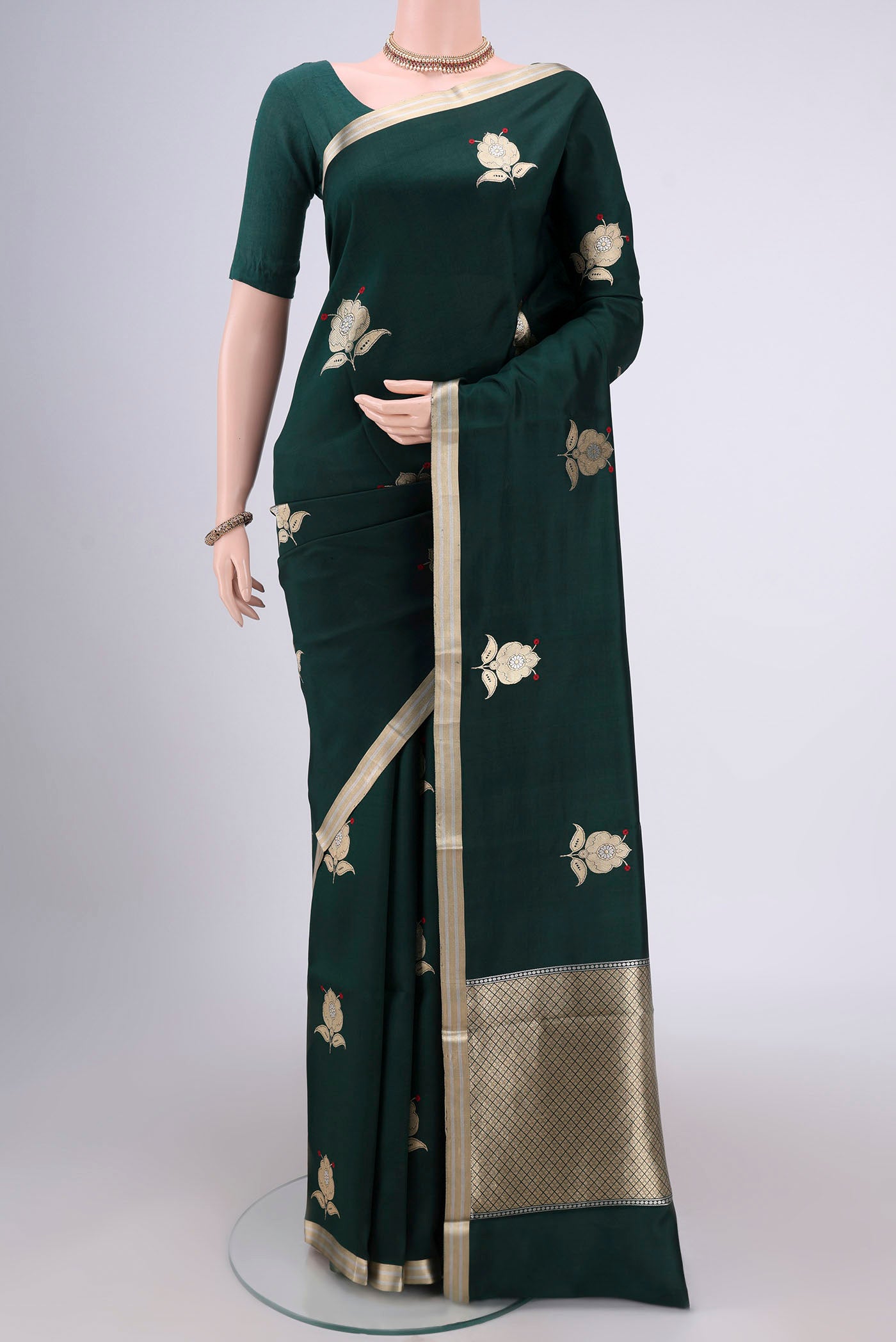 Bottle Green Banarasi Katan Silk Saree with Zari Butta on the body and Zari Border.  displayed on a mannequin