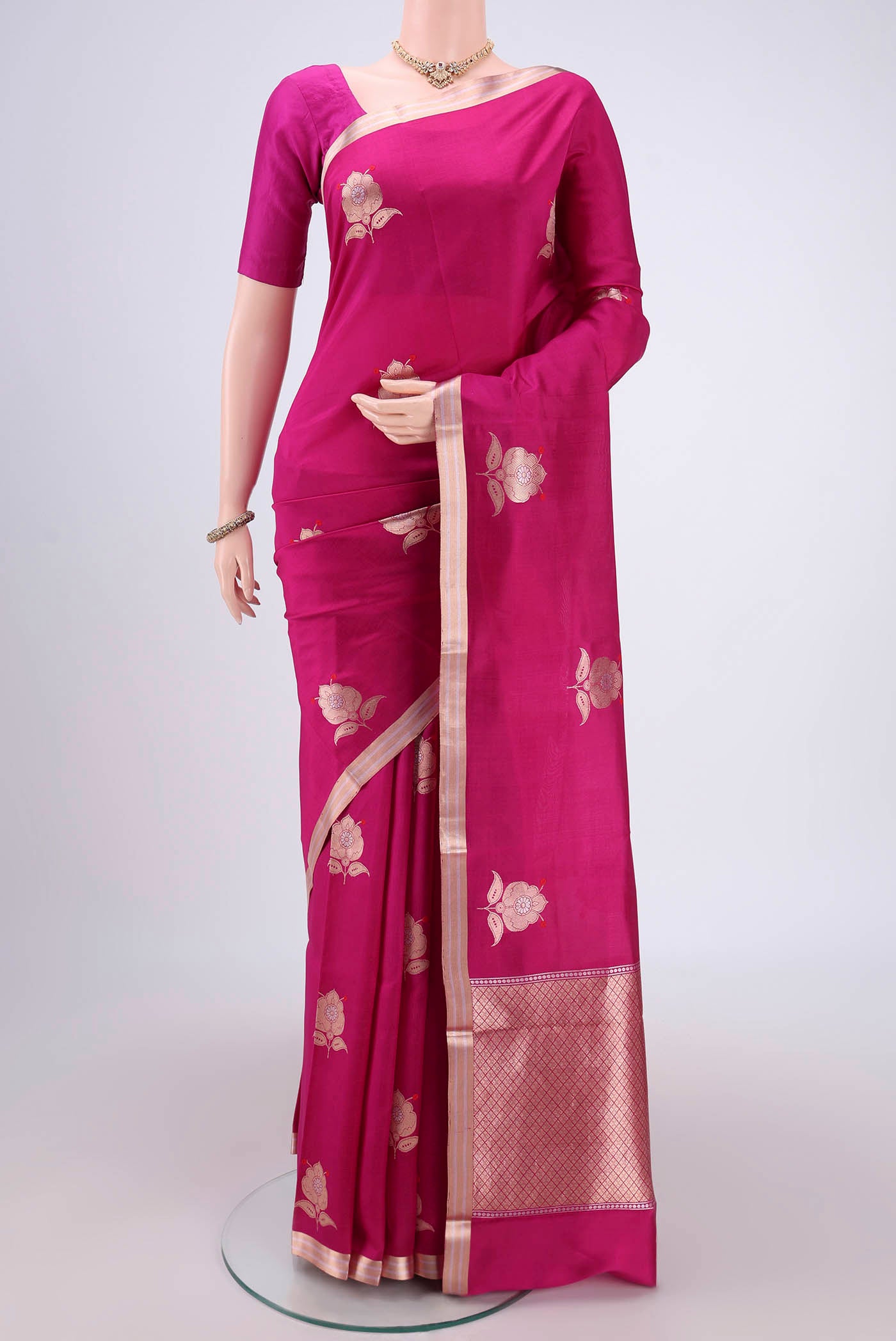 Rani Pink Banarasi Katan Silk Saree with Zari And Thread Butta on the body and Zari Border.  displayed on a mannequin