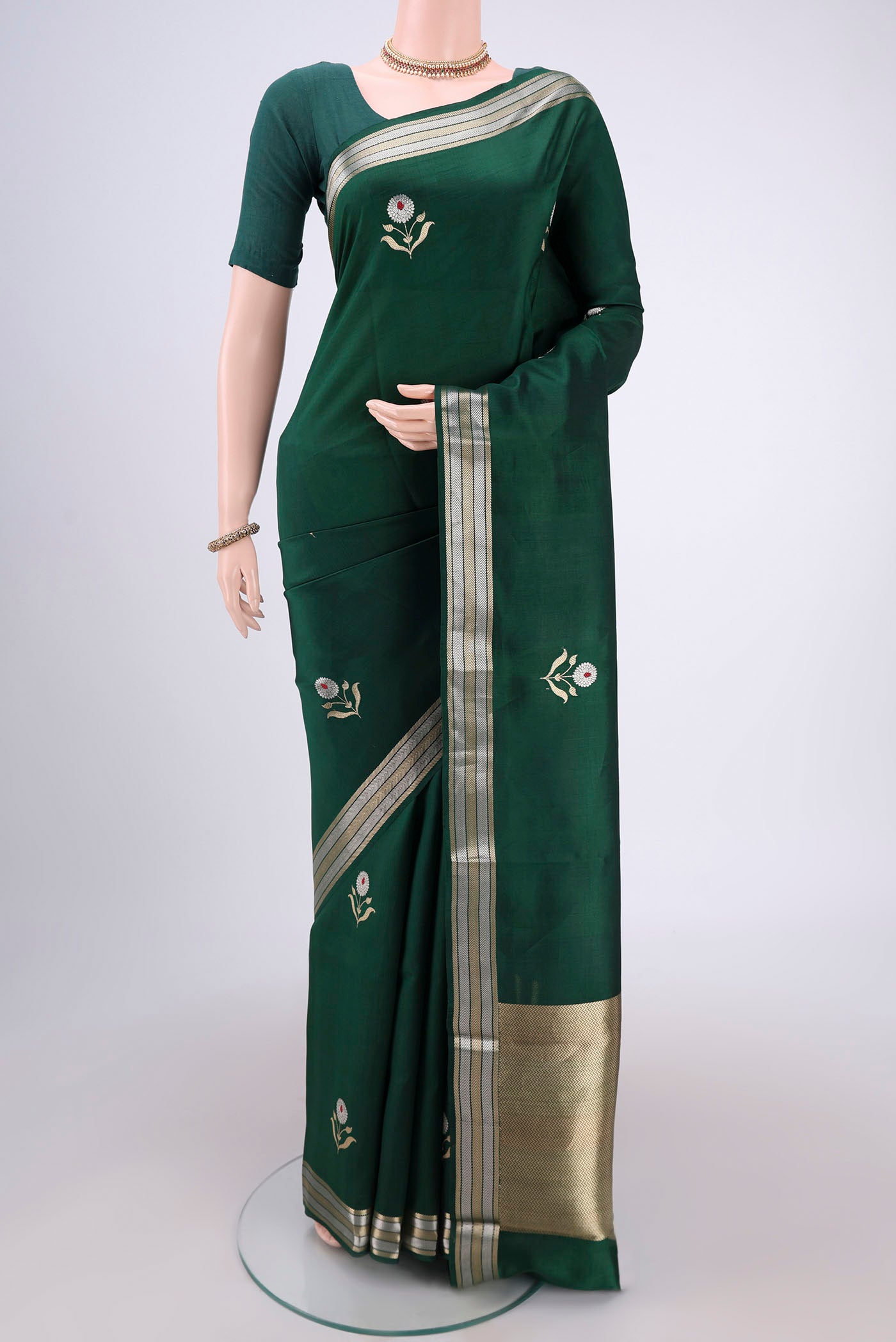 Bottle Green Banarasi Katan Silk Saree with Zari And Thread Butta on the body and Zari Border.  displayed on a mannequin