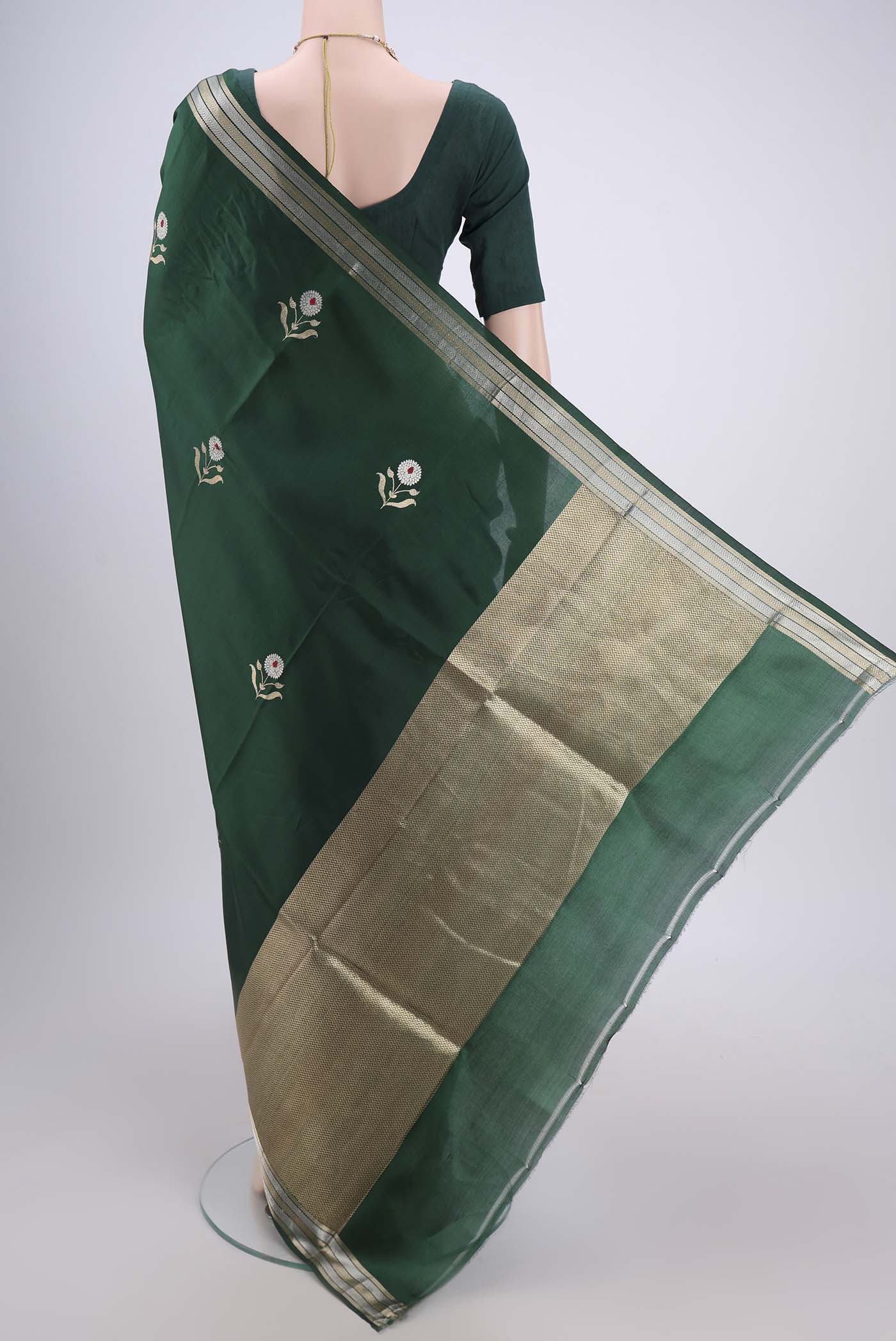 Flat view of Bottle Green Banarasi Katan Silk Saree with Zari And Thread Butta on the body and Zari Border. 