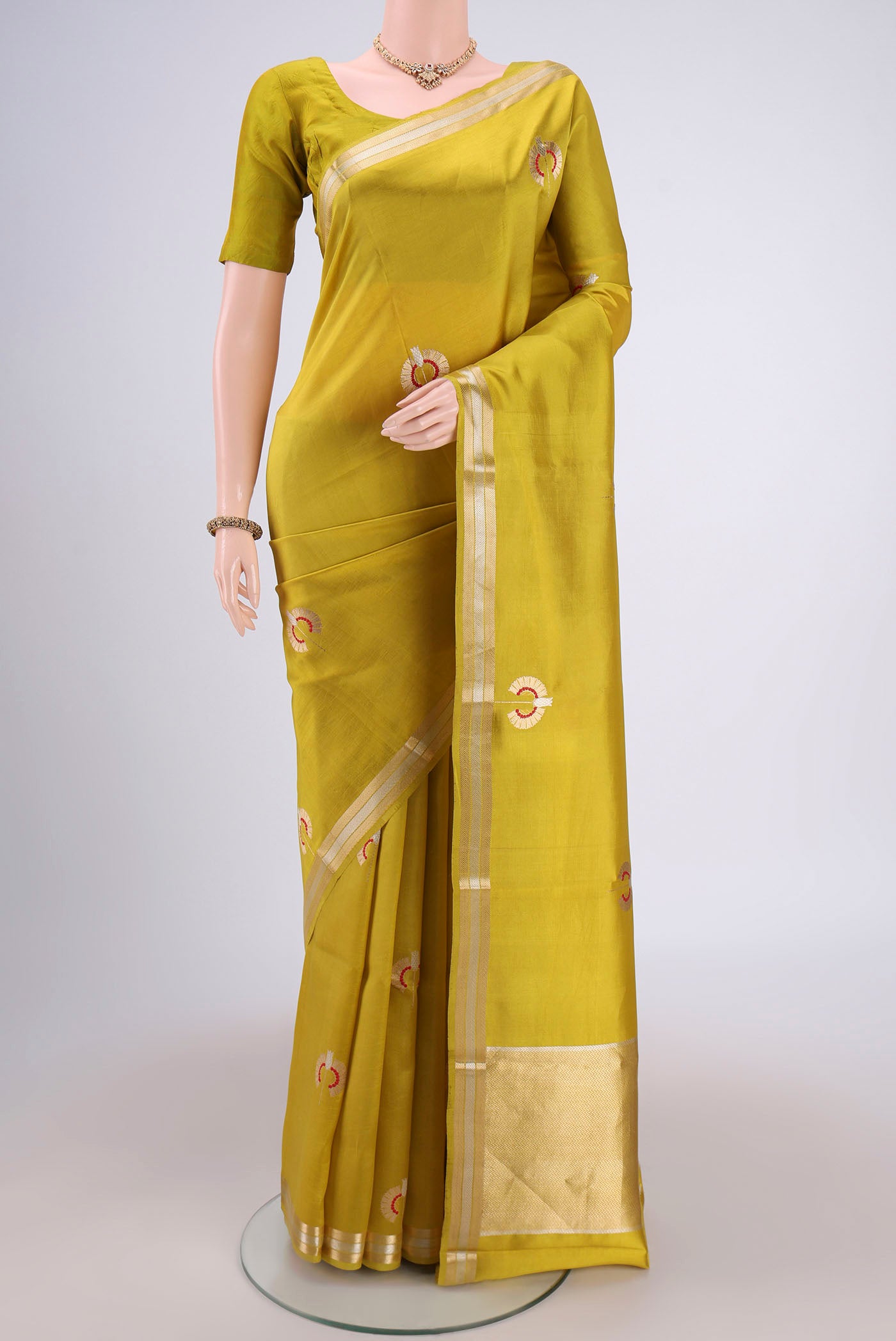 Light Green Banarasi Katan Silk Saree with Zari Butta on the body and Zari Border.  displayed on a mannequin