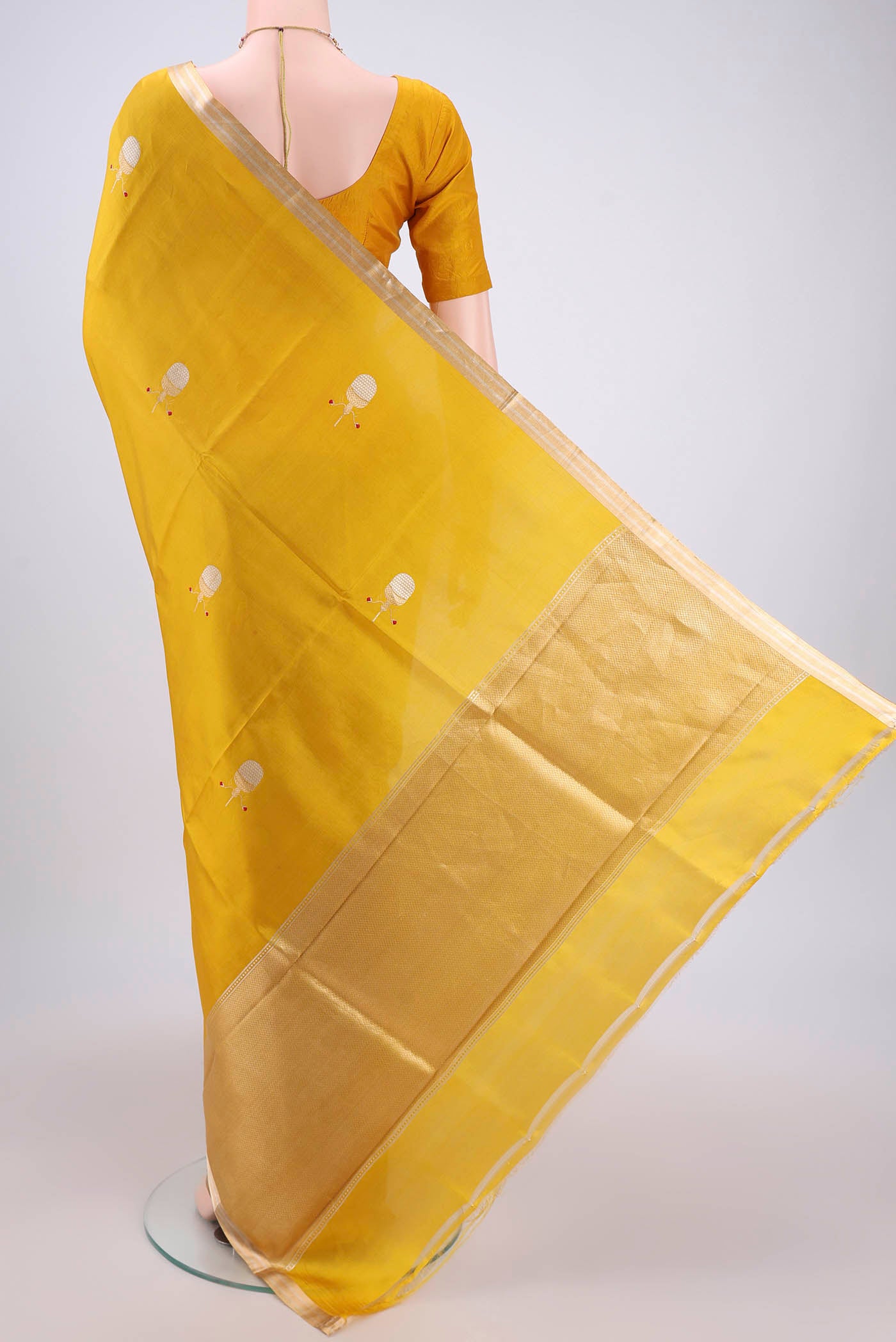 Flat view of Mustard Banarasi Katan Silk Saree with Zari Butta on the body and Zari Border. 