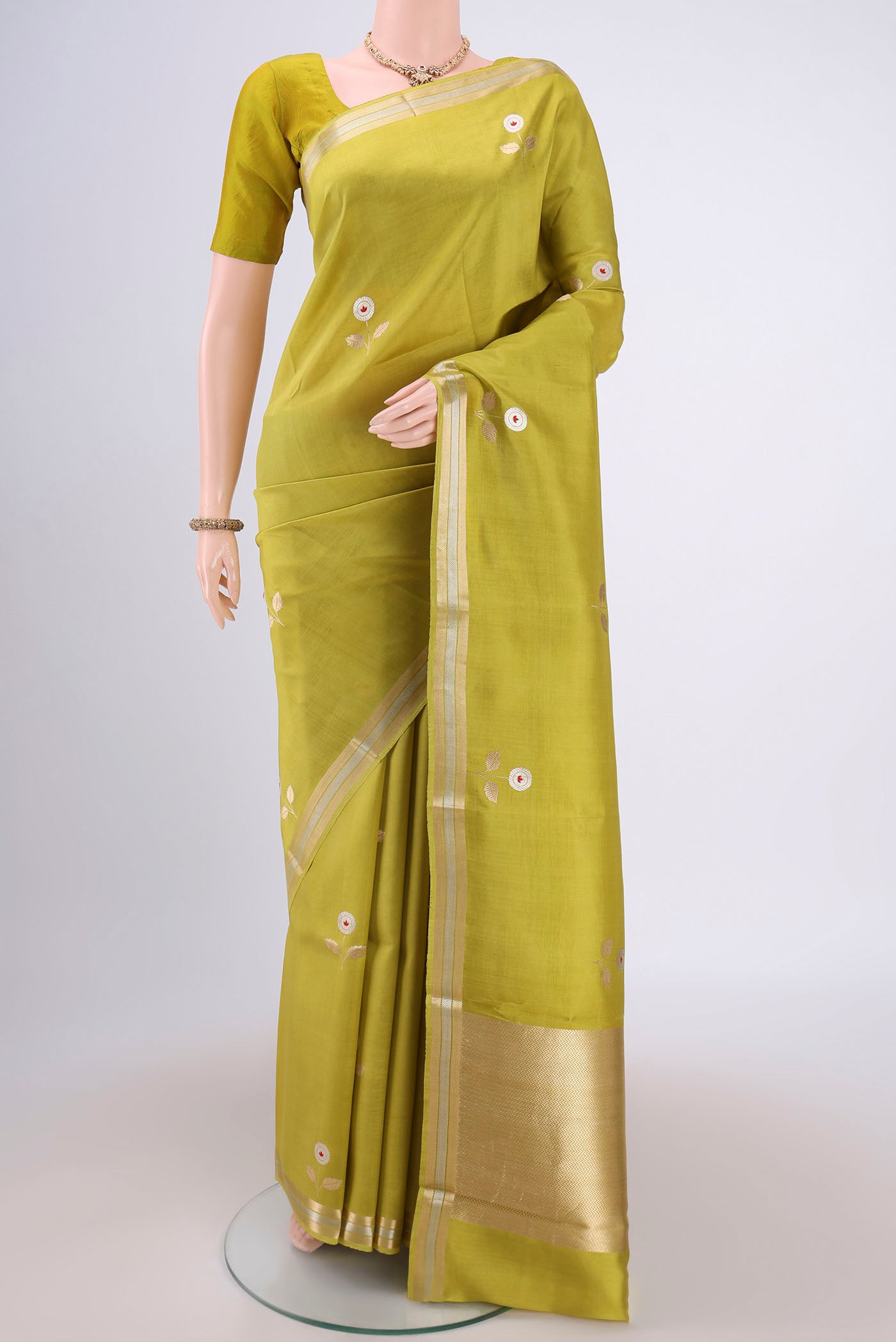 Light Green Banarasi Katan Silk Saree with Zari Butta on the body and Zari Border.  displayed on a mannequin