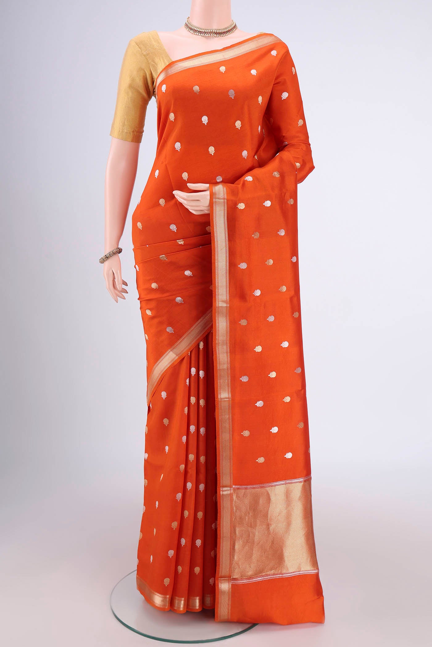Rust Banarasi Katan Silk Saree with Zari Butta on the body and Zari Border.  displayed on a mannequin