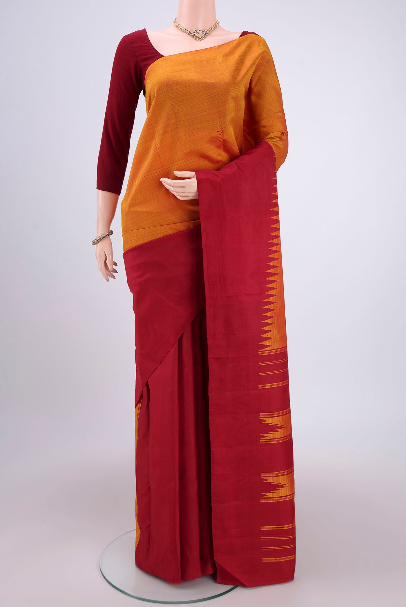 Orange Dual Tone Kanchipuram Silk Saree with Plain Body and Temple Border.  displayed on a mannequin